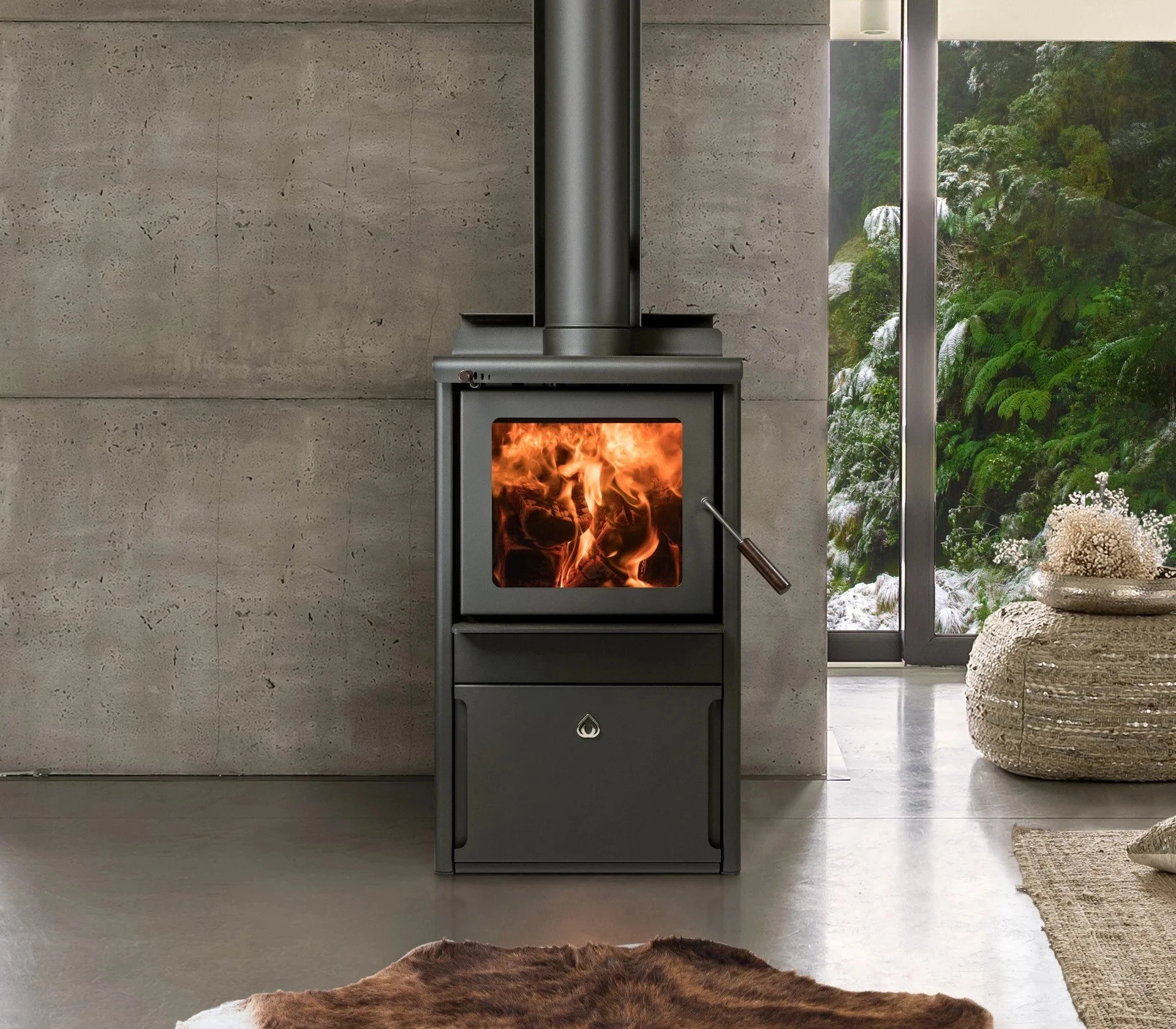 Modern wood-burning stove with visible flames, set against a concrete wall, near a large window with a forest view. Cozy interior with a fur rug and woven poufs.