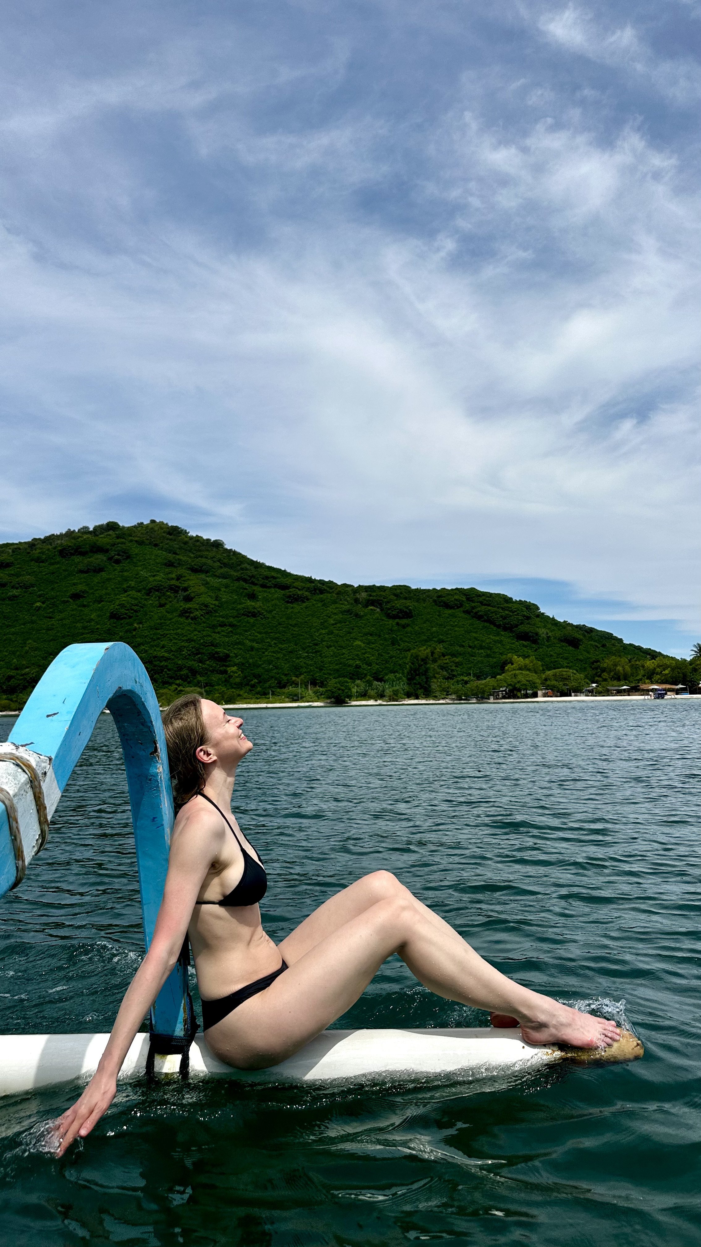 Traveller sitting on the edge of a boat near Gili Nanggu in Lombok