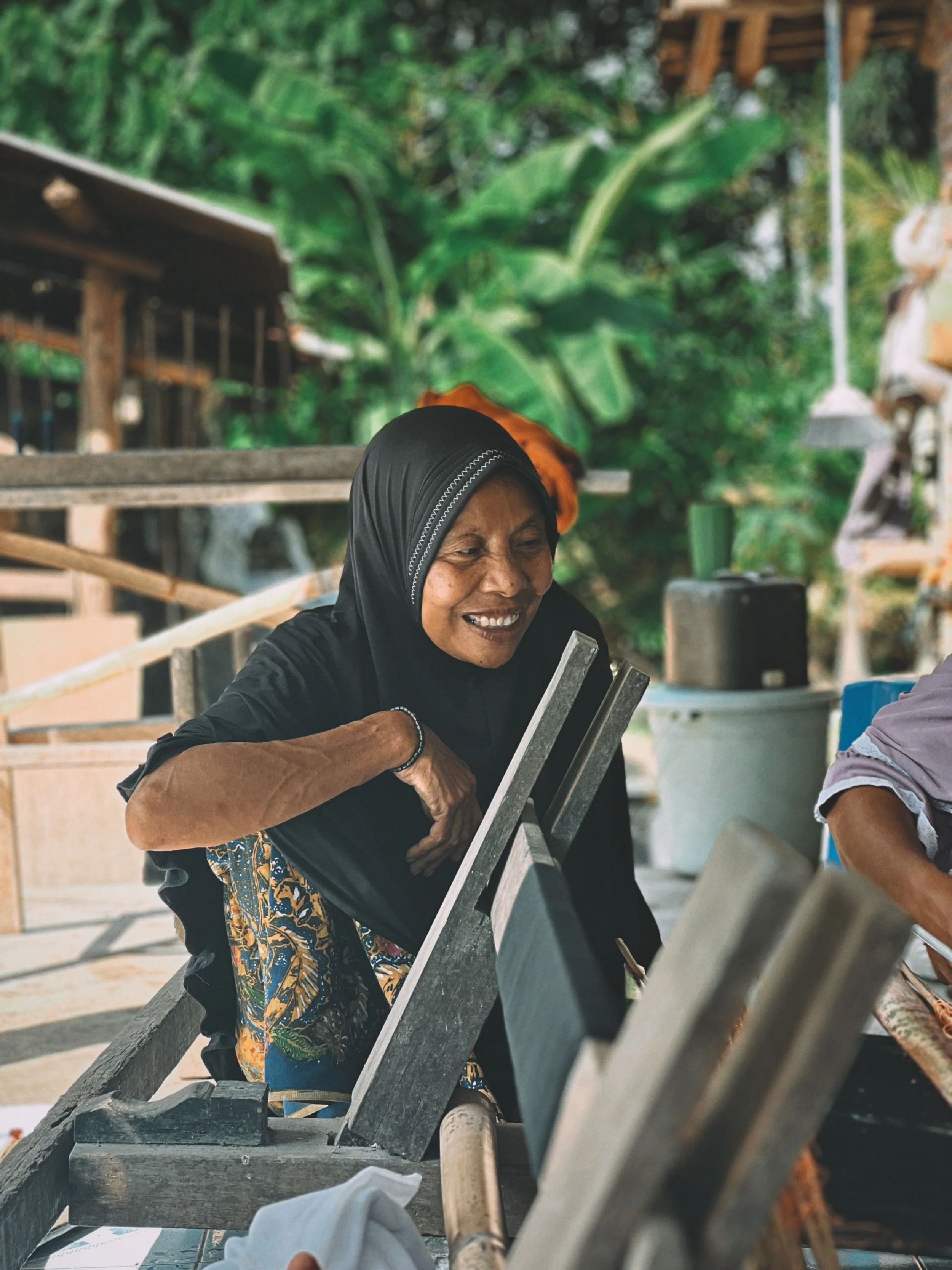 Local woman smiling during a cultural stop on the Benang Stokel and Benang Kelambu tour