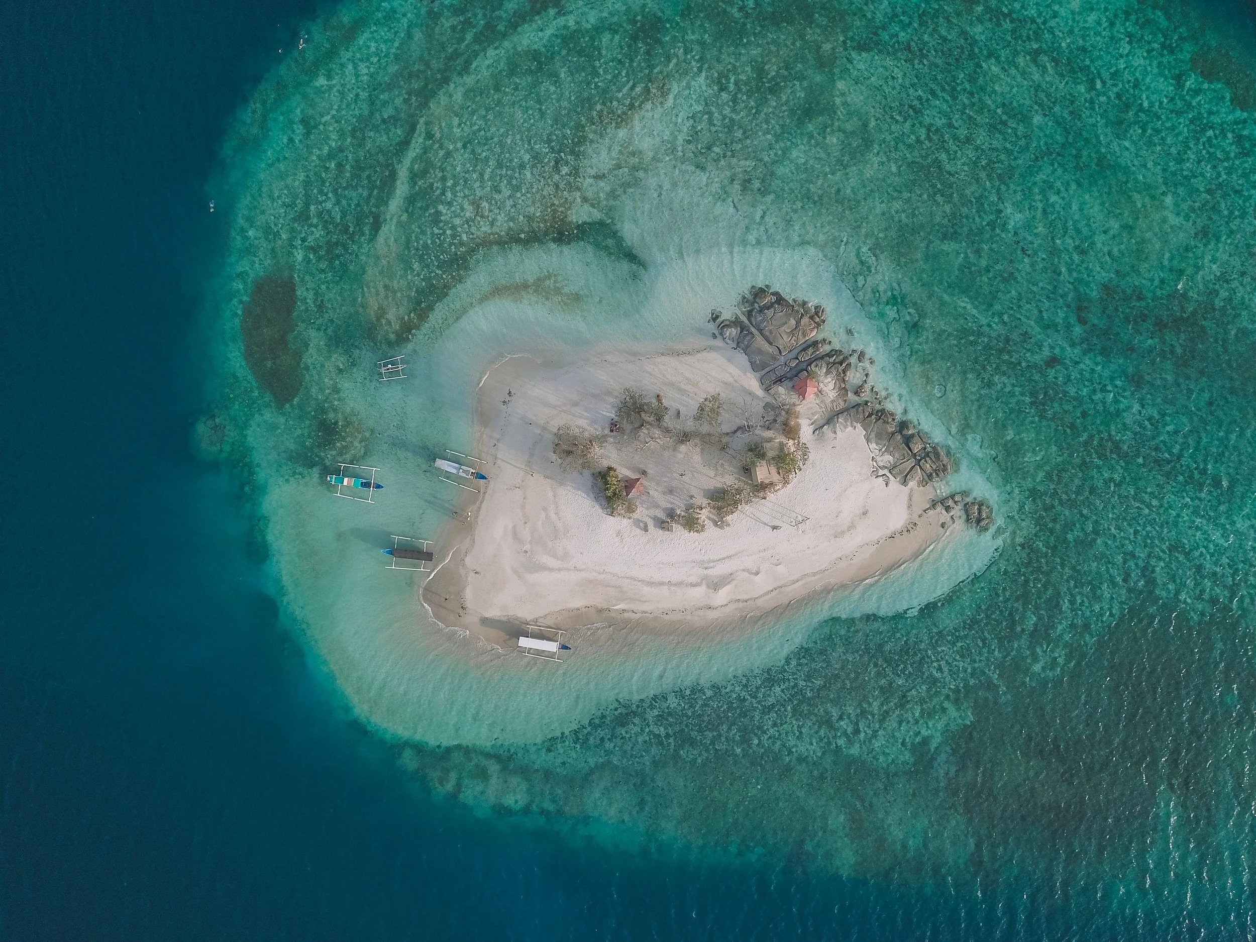 Aerial view of a tiny island surrounded by turquoise water near Gili Kedis