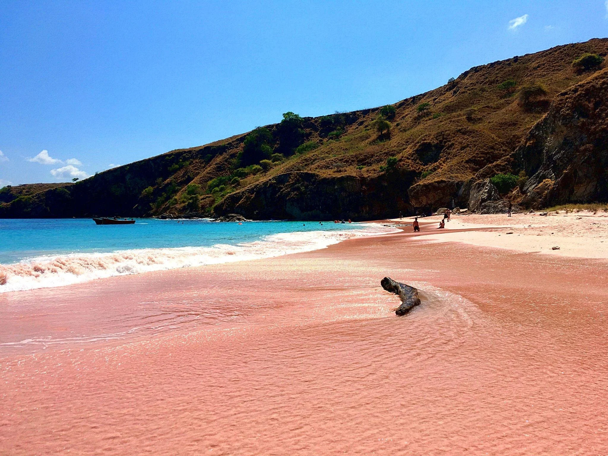 Soft pink sand and clear blue water at Pink Beach in Lombok