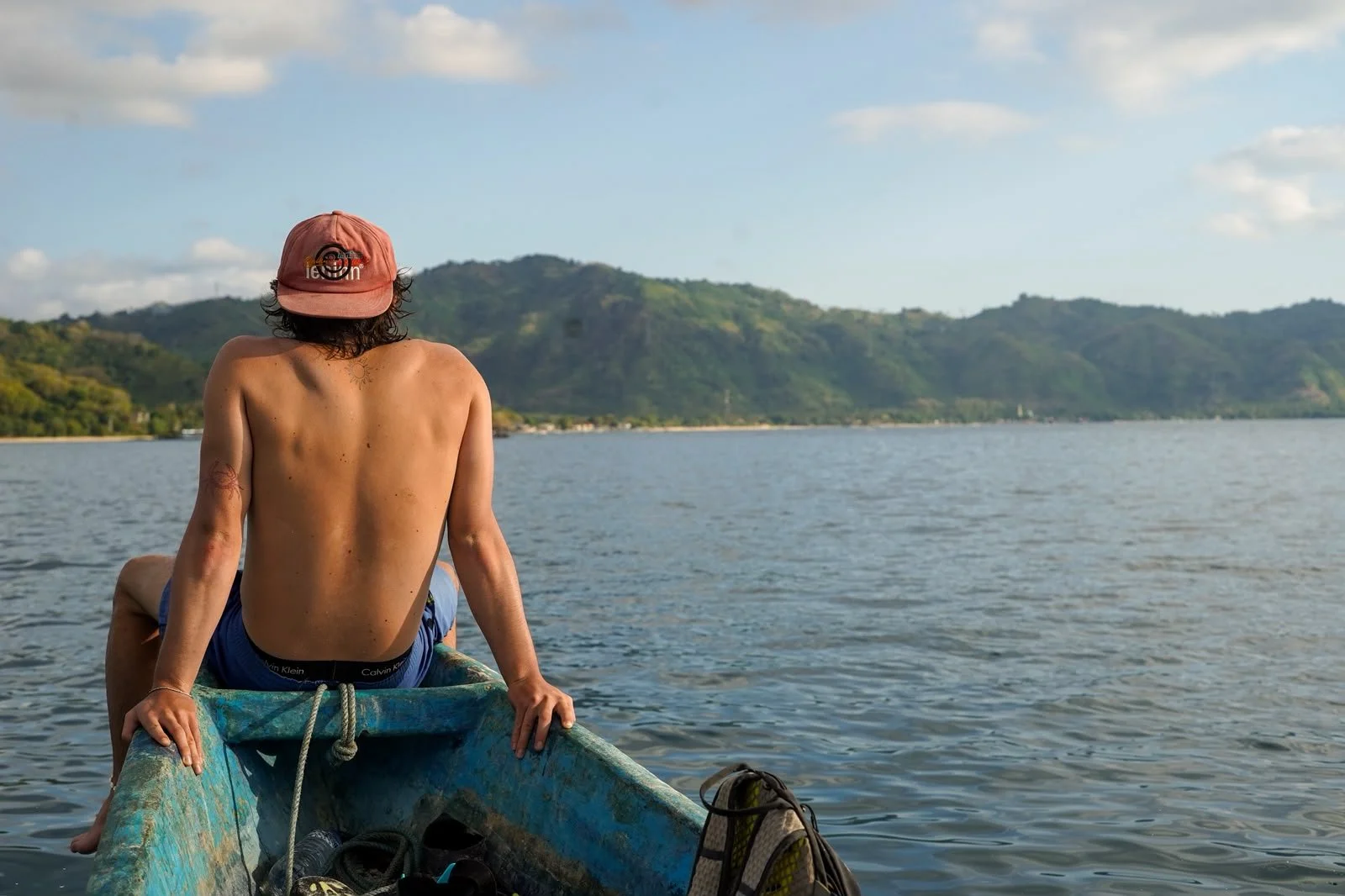 Traveller sitting at the end of a boat near Gili Sudak in Lombok