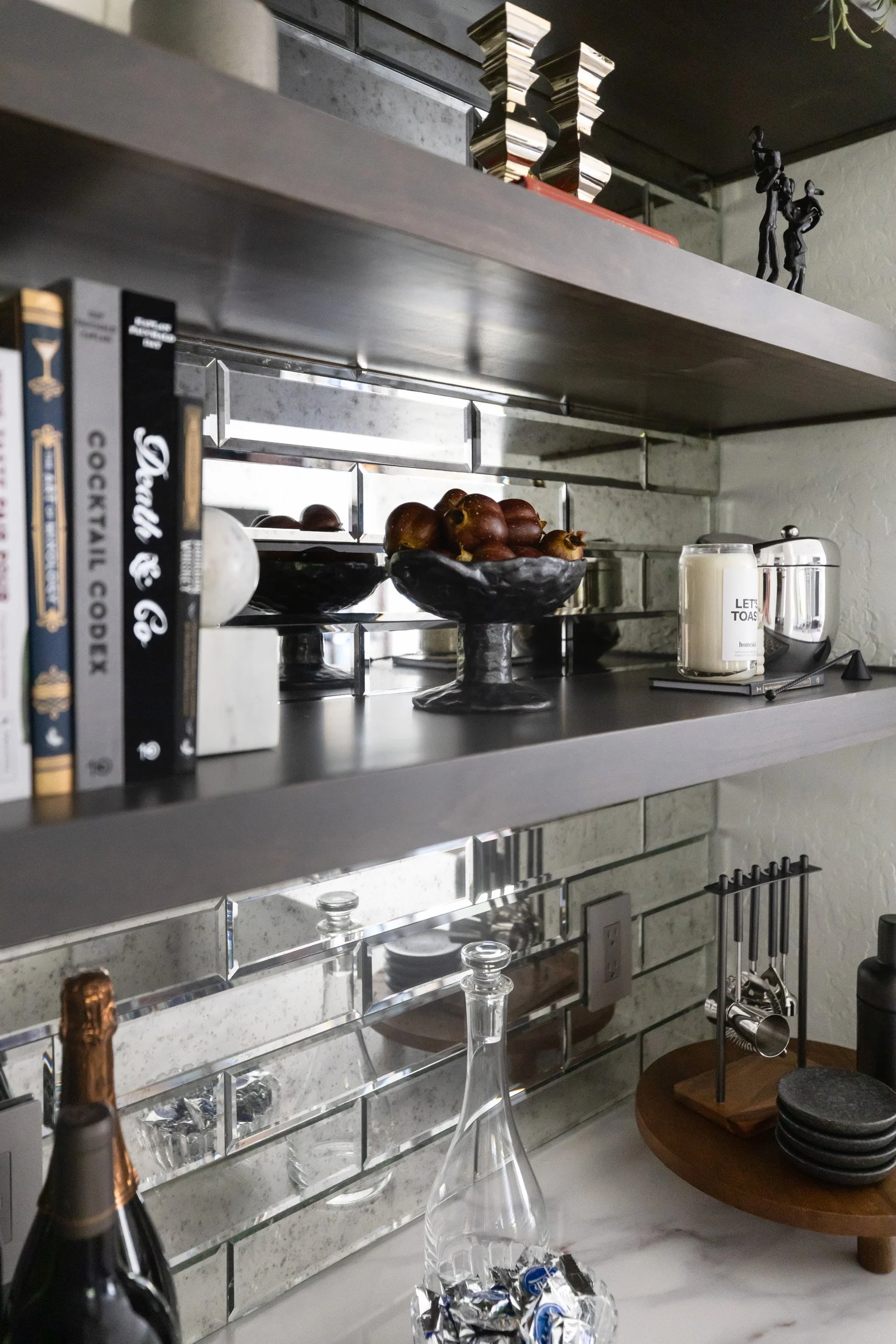 Styled wine bar shelves with books, champagne and mirrored backsplash, Arizona