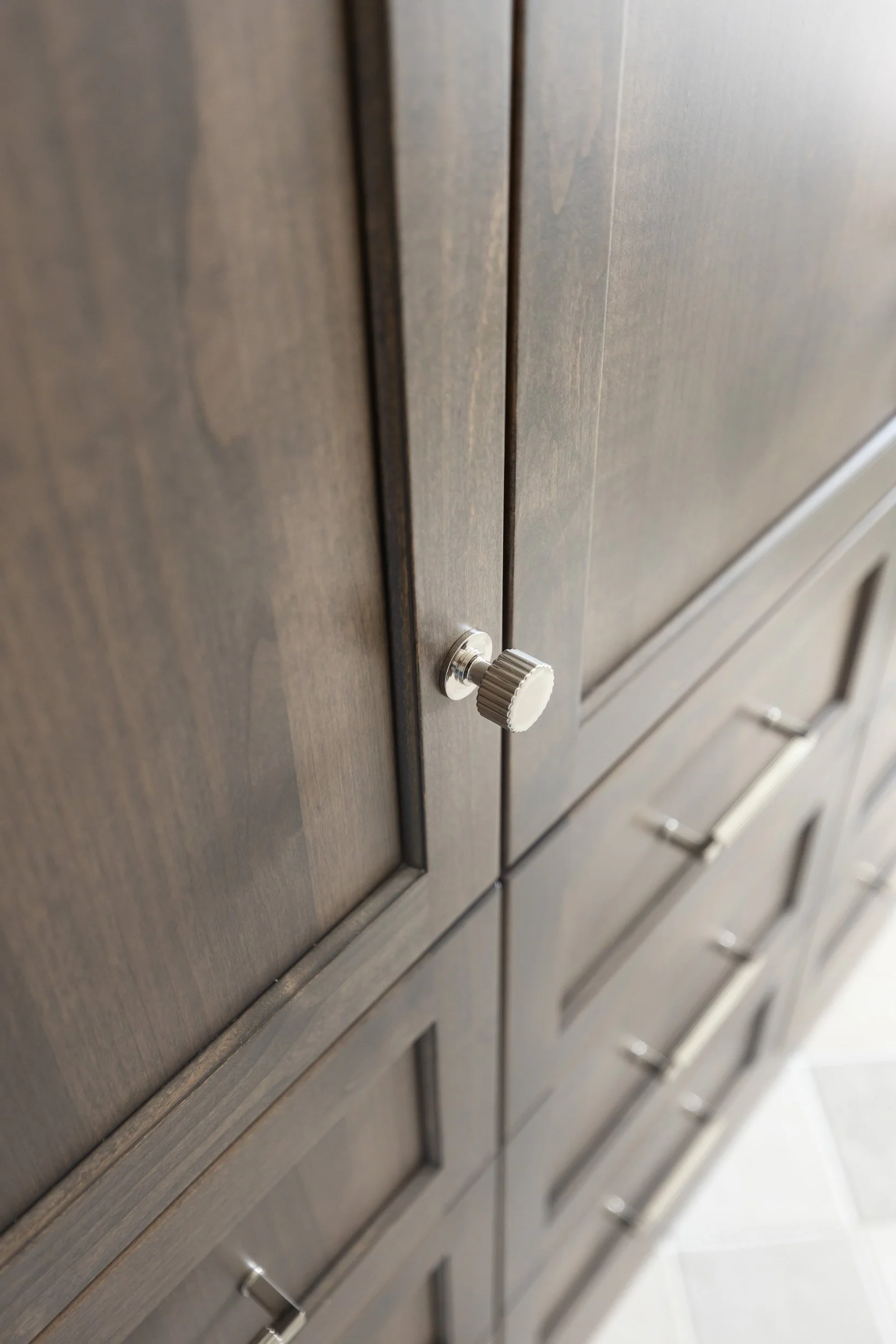 Dark stained wood cabinet doors with brushed nickel hardware in a Desert Ridge bathroom