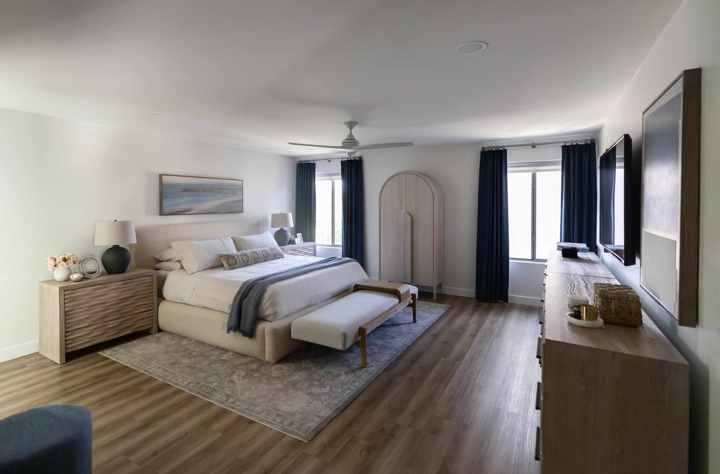 Primary bedroom with upholstered bed, end-of-bed bench and long wood dresser in Phoenix