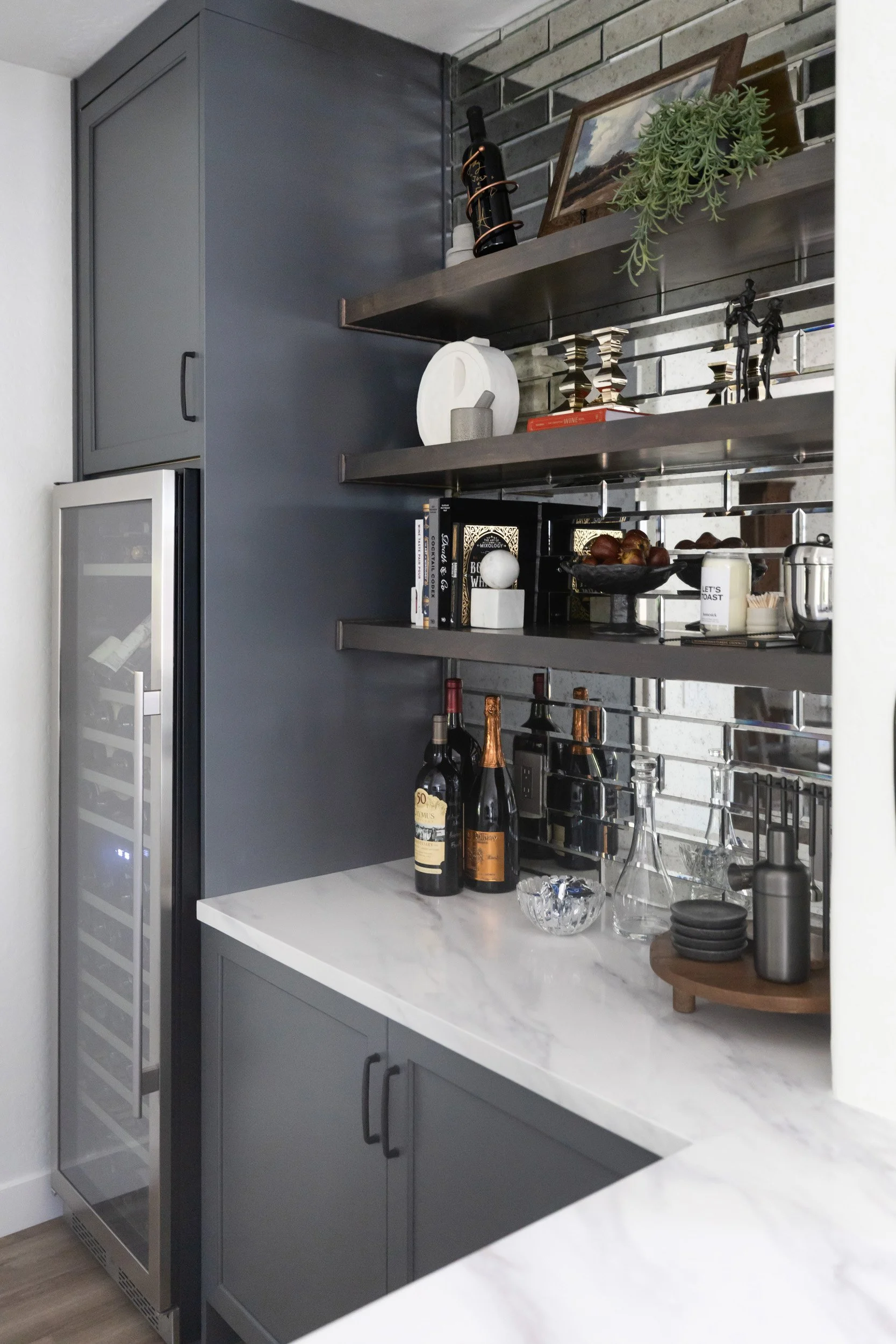 Wine bar open shelving with glassware and bottles above a marble counter in Arizona