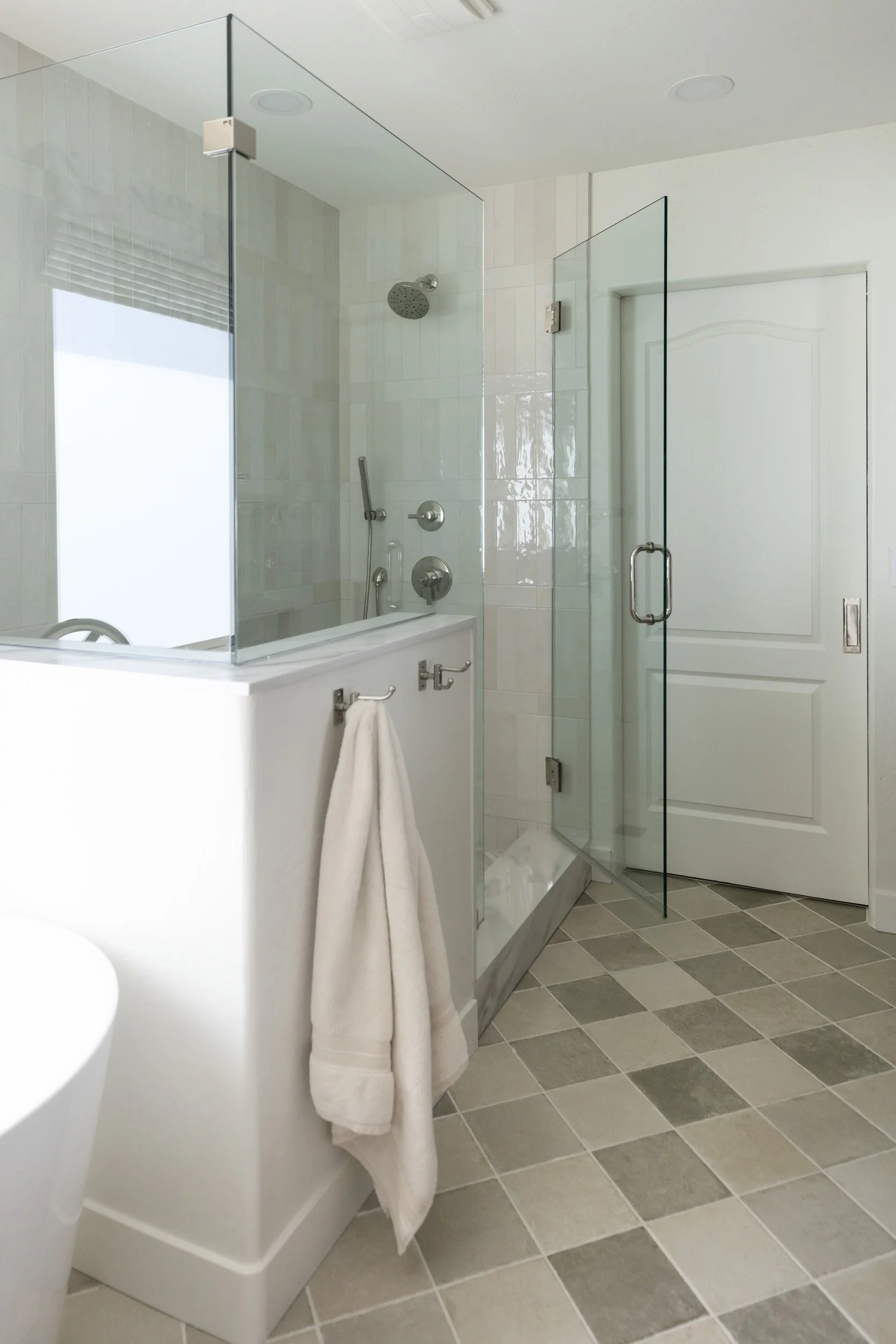 Glass walk-in shower and checkered floor tile in a Phoenix primary bathroom