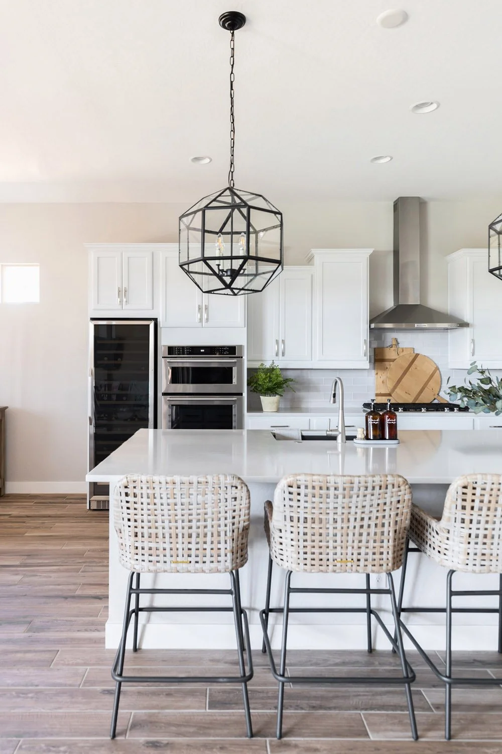 Kitchen with white quartz island and rattan bar stools