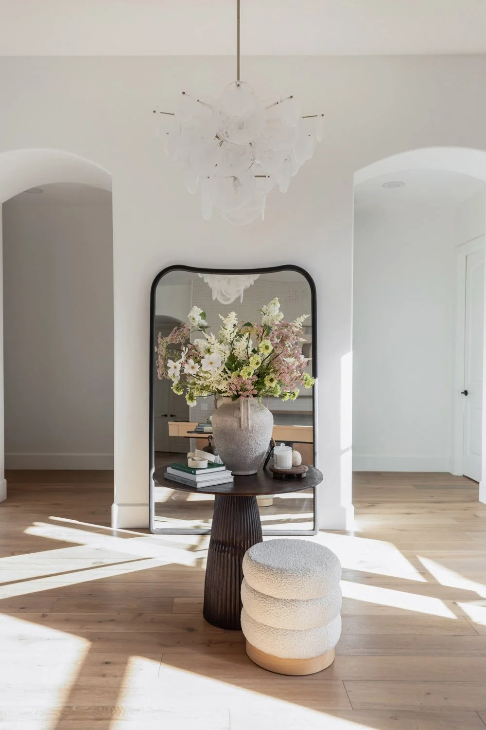 Hidden Hills interior design project that included a floral arrangement in rustic stone vase styled on round wood table with ottomans.