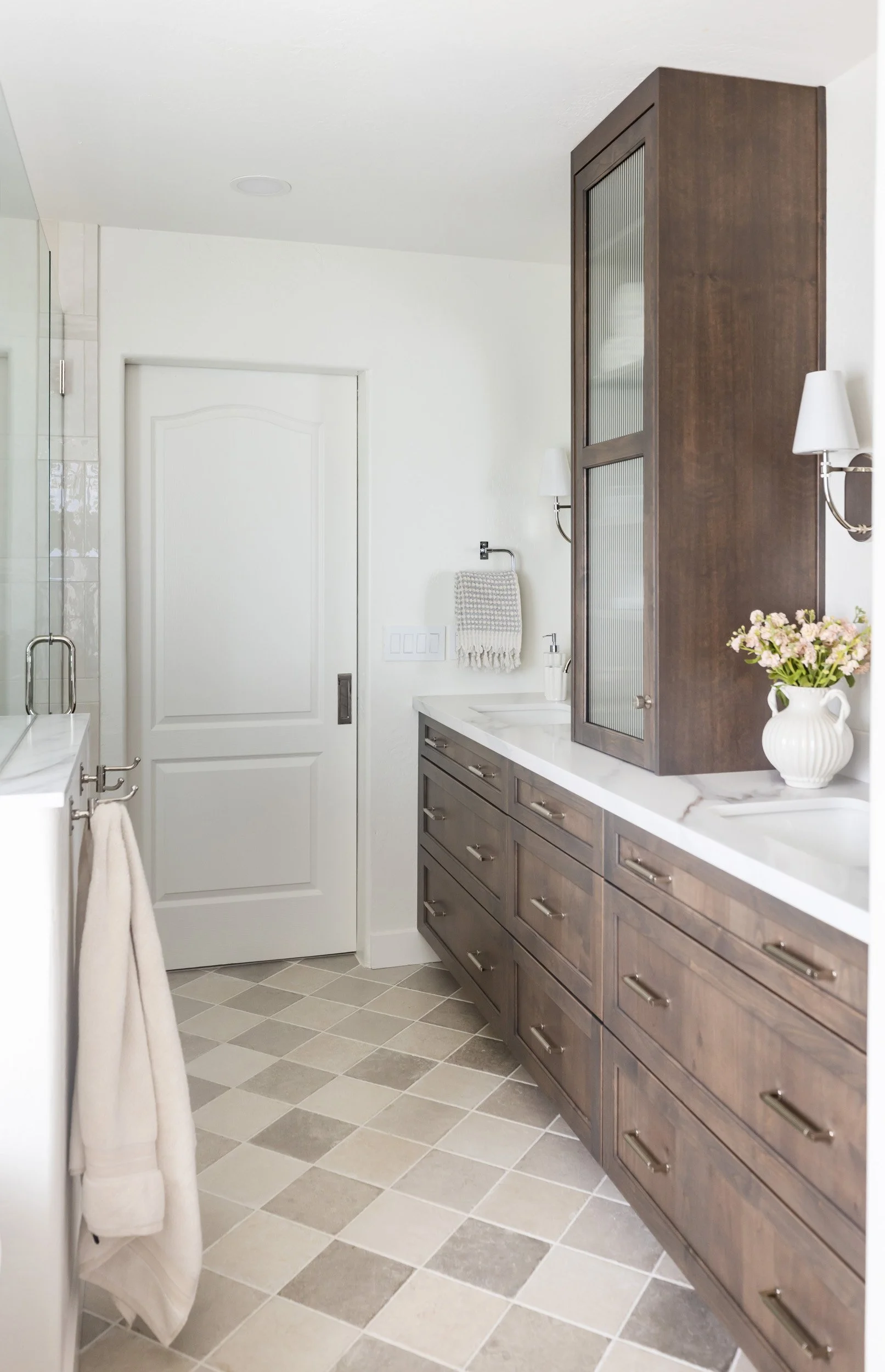 Long dark wood vanity and checkered tile floor in a Desert Ridge primary bathroom