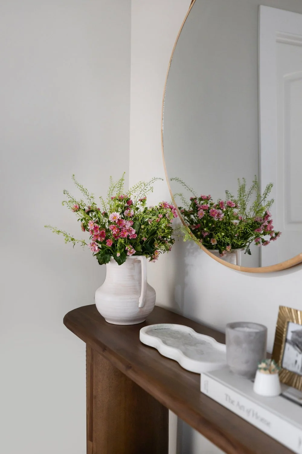Hallway detail with dark wood console, and white ceramic vase with pink floral arrangement in an Arcadia home