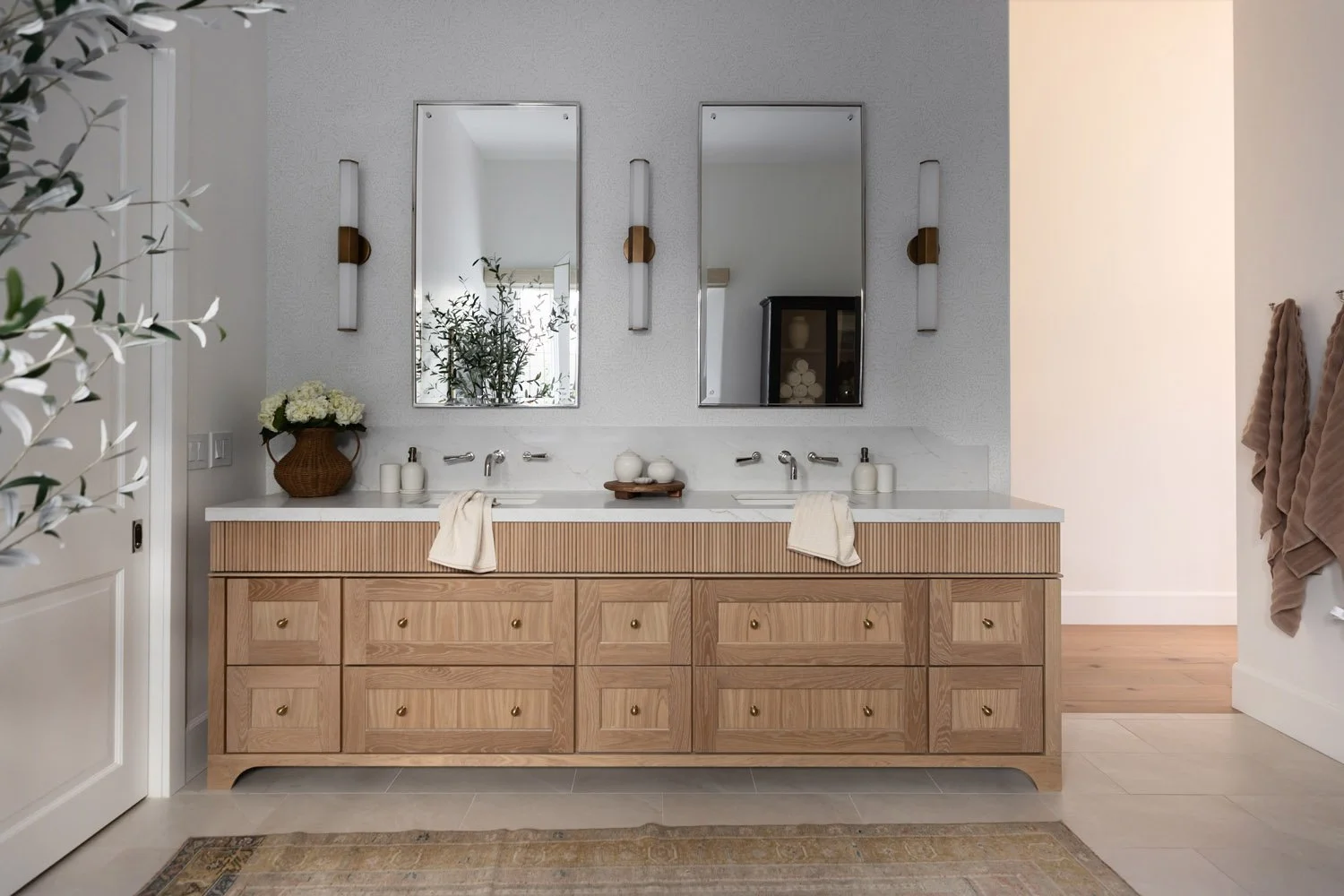 Arizona bathroom design with double vanity with framed mirrors, wall sconces, and warm oak drawers. 