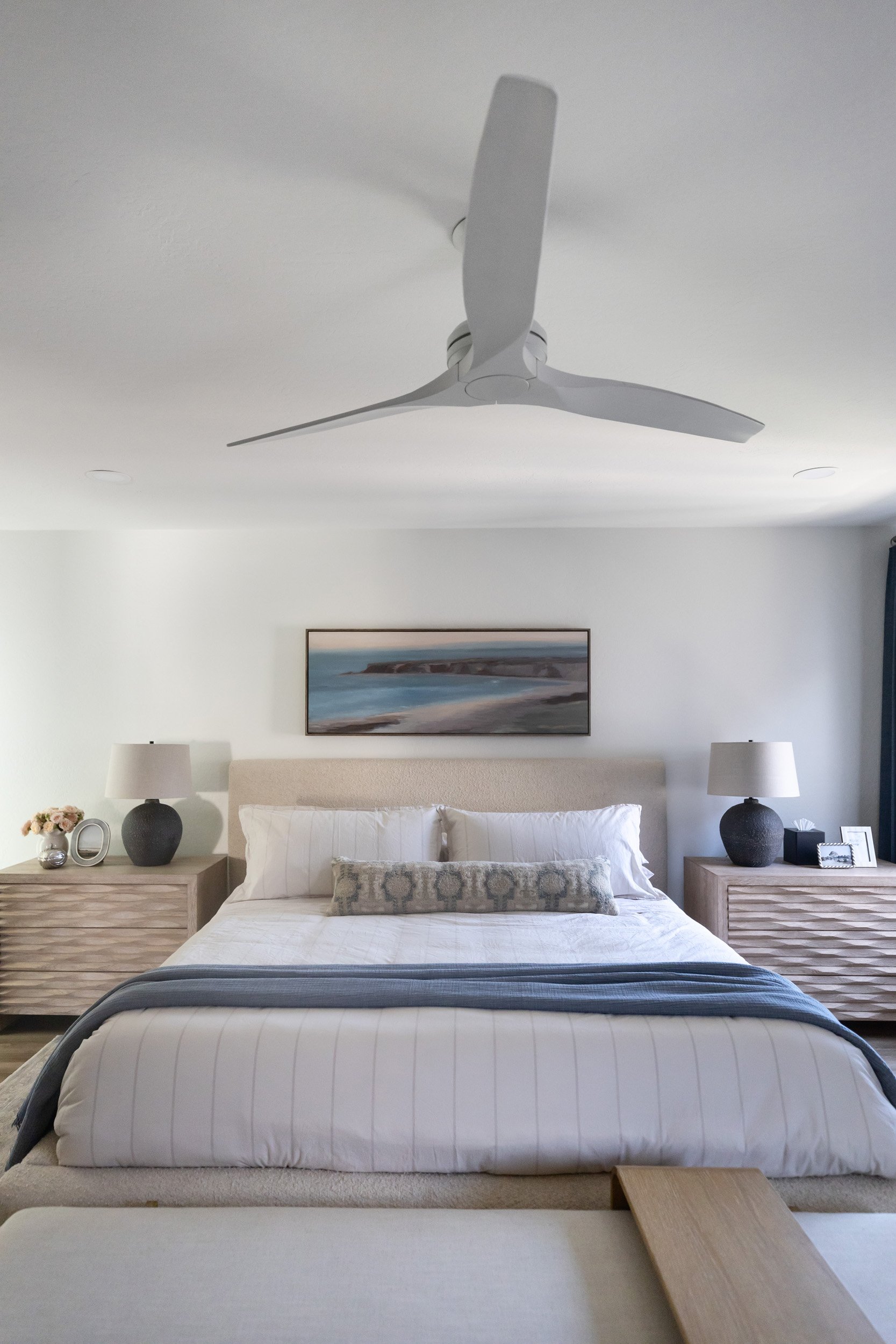 Primary bedroom with upholstered bed, matching nightstands and ceiling fan in a Phoenix home