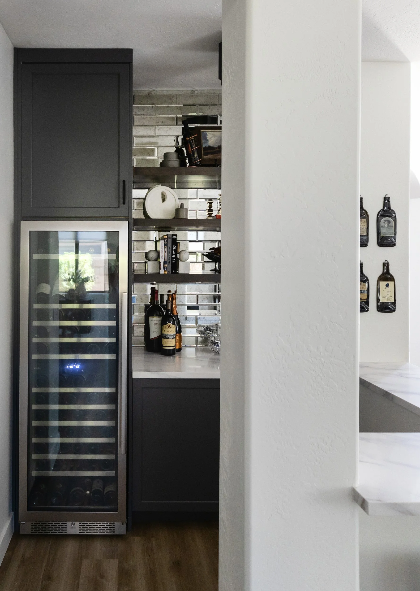 Built-in wine fridge beside black cabinetry in a Phoenix home wine bar