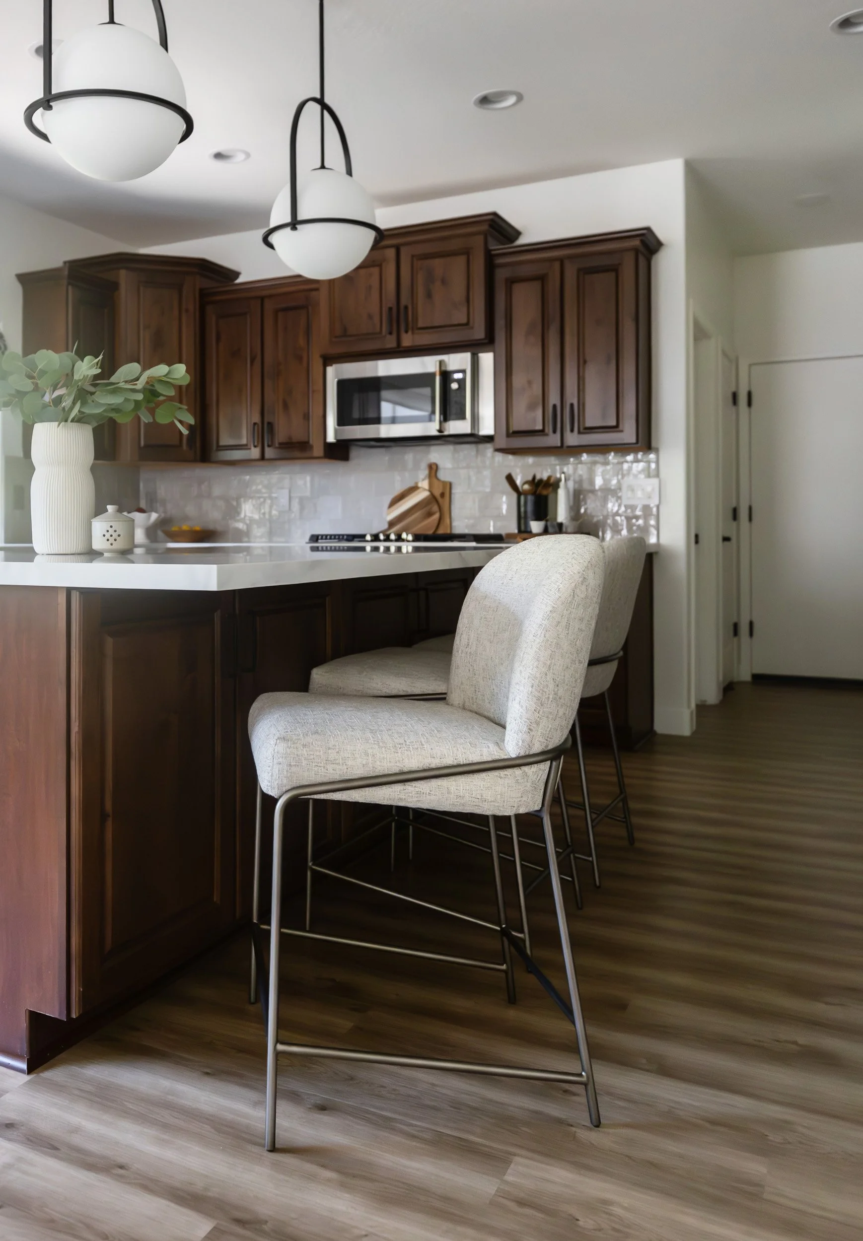 White upholstered counter stools at a marble kitchen island in Desert Ridge