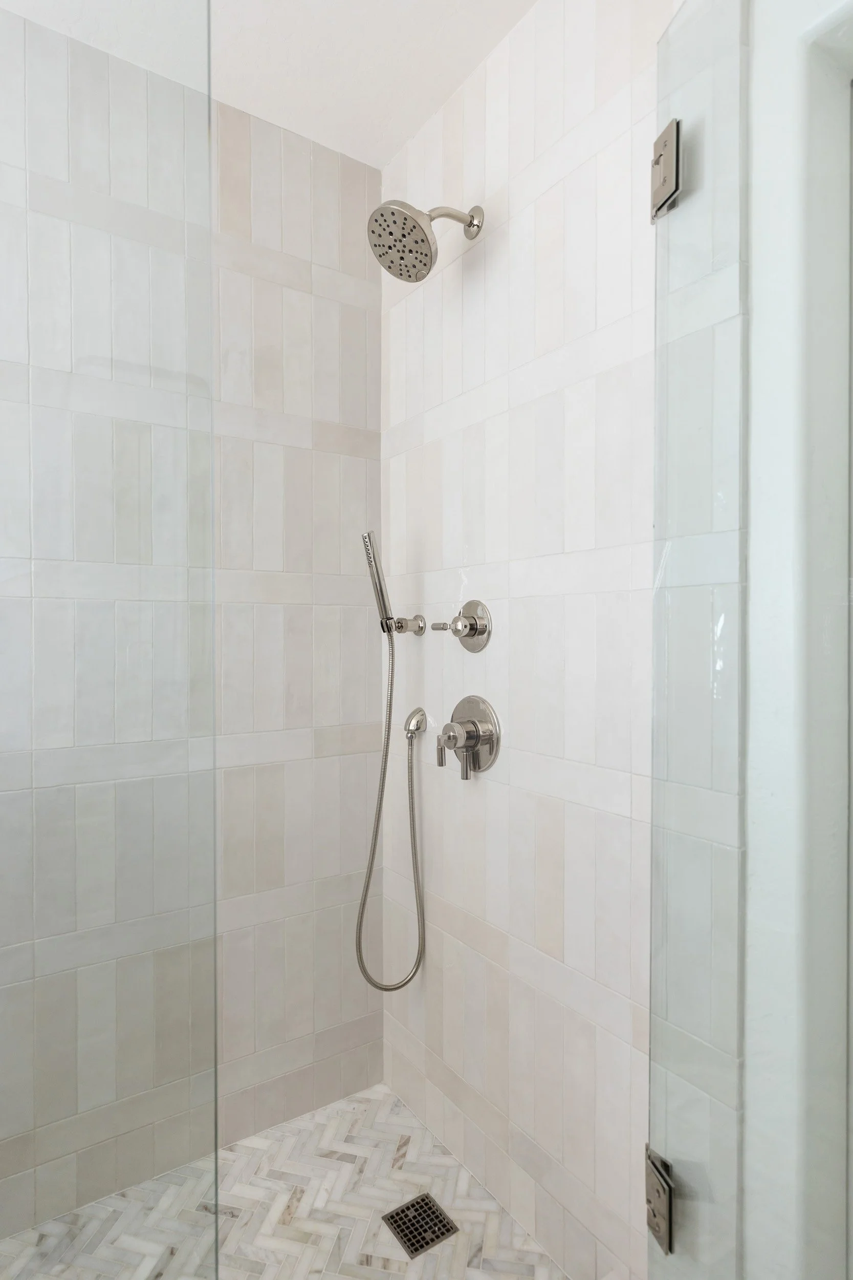 Walk-in shower with marble-look tile, glass door and nickel fixtures in Desert Ridge