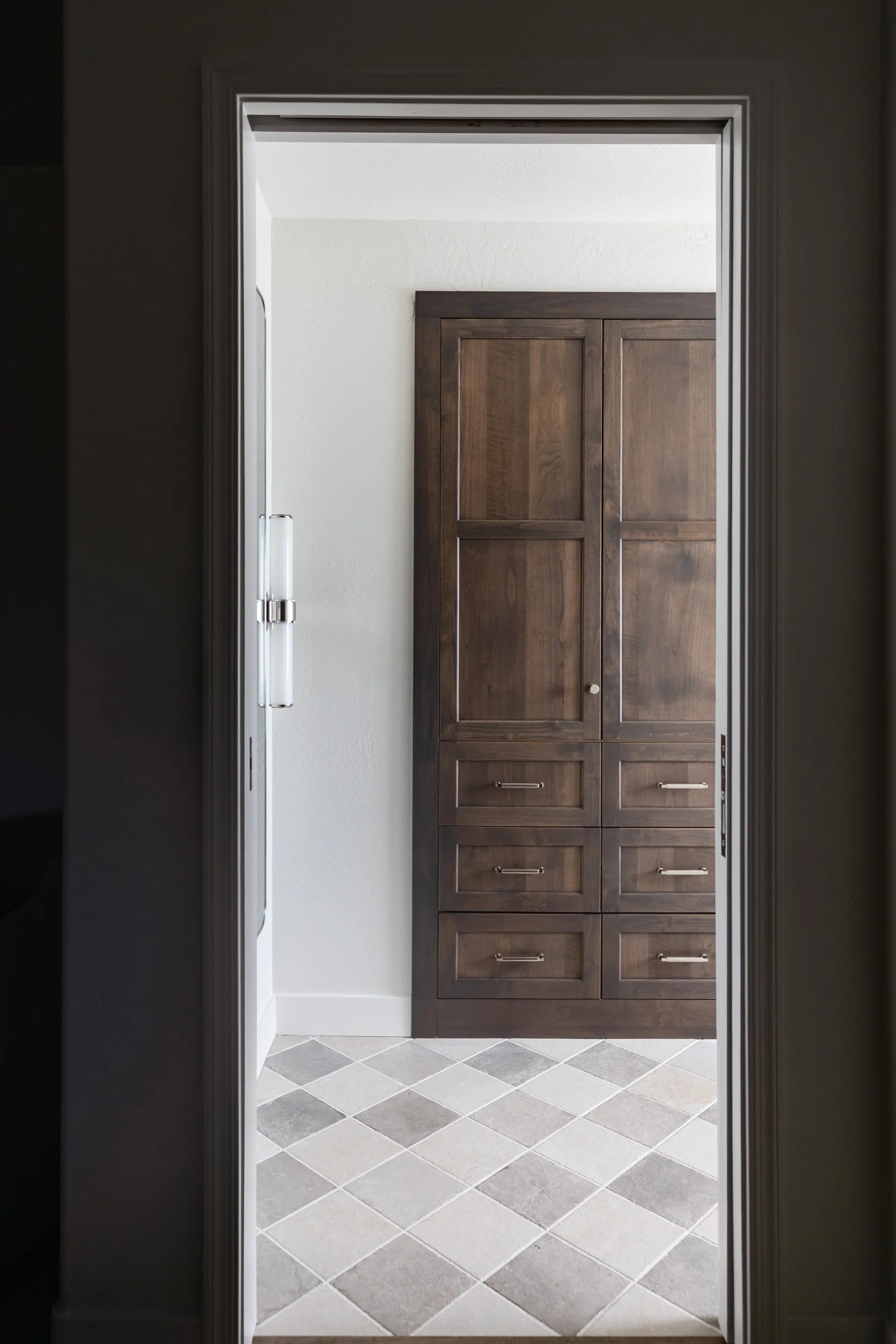 View from the primary bedroom into the bathroom's dark wood linen cabinet, Phoenix