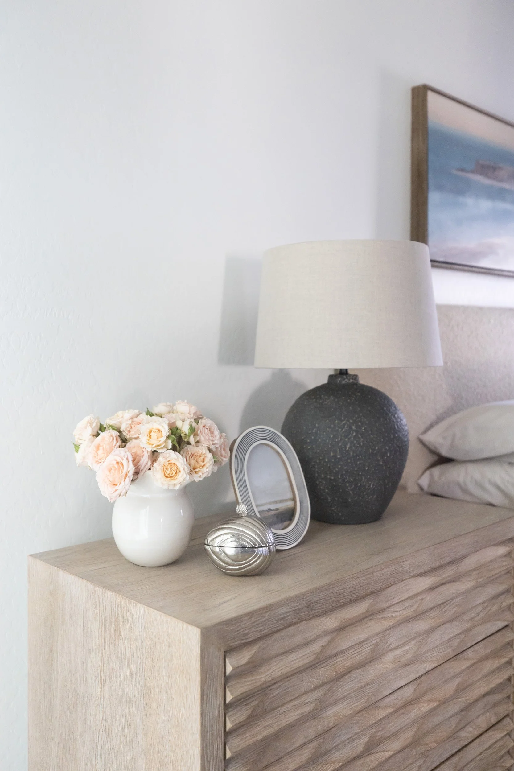 Nightstand styled with lamp, roses and ceramic vase in a Desert Ridge primary bedroom