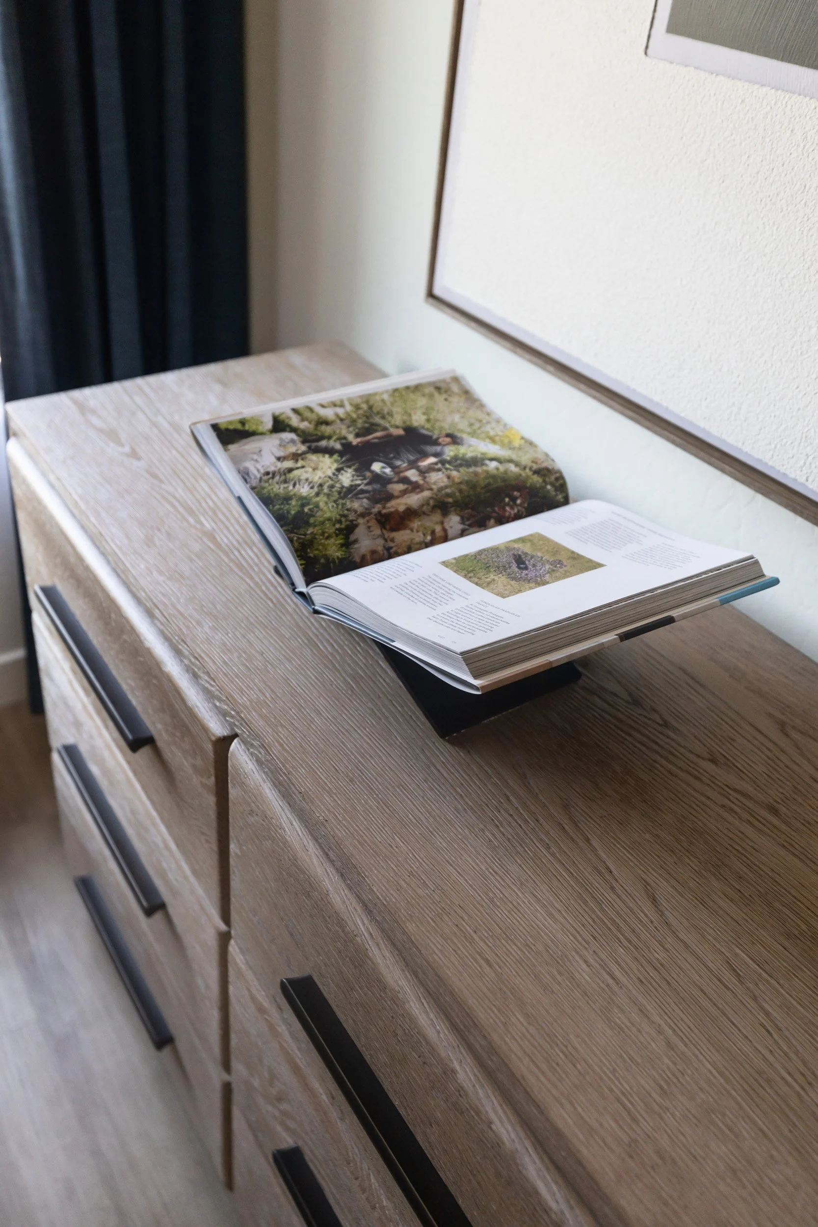 Coffee table books styled on a wood dresser in a Phoenix primary bedroom