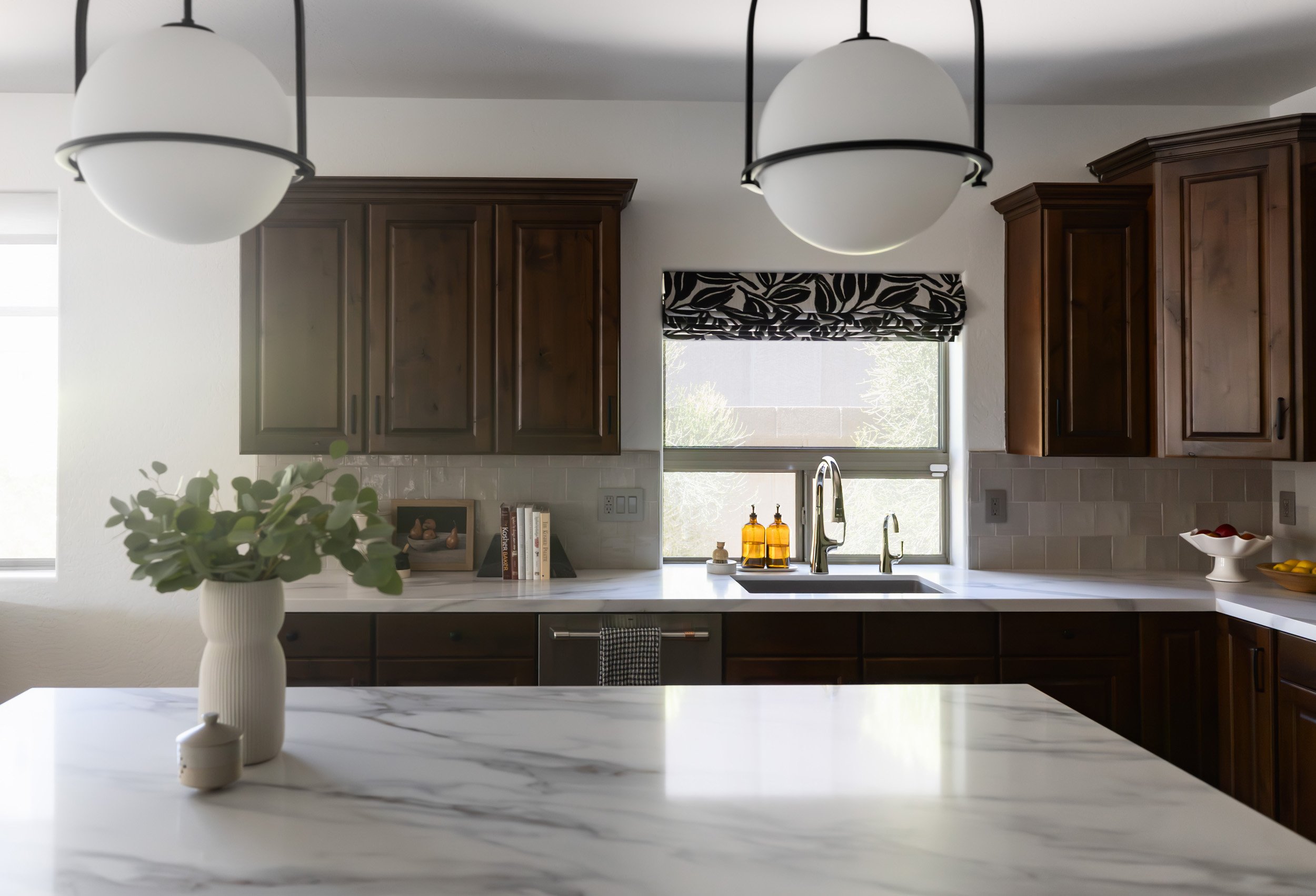 Marble kitchen island with two globe pendant lights in an Arizona kitchen