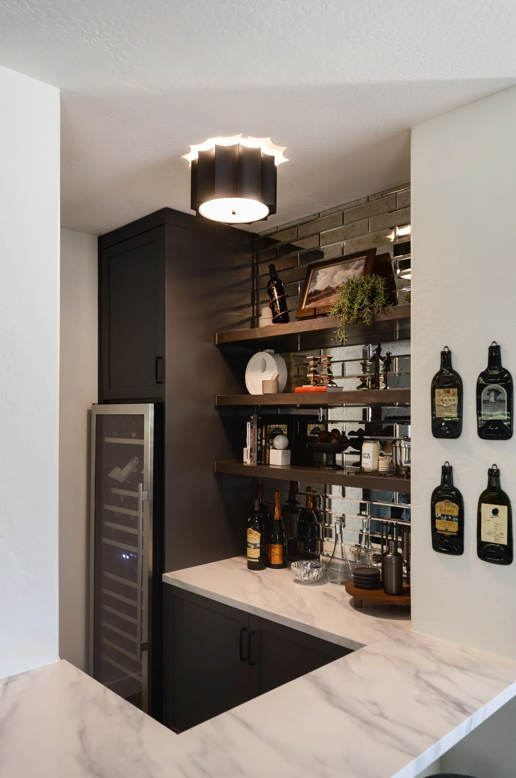 Wine bar with black cabinetry, marble countertop and wall-mounted wine bottle rack, Phoenix