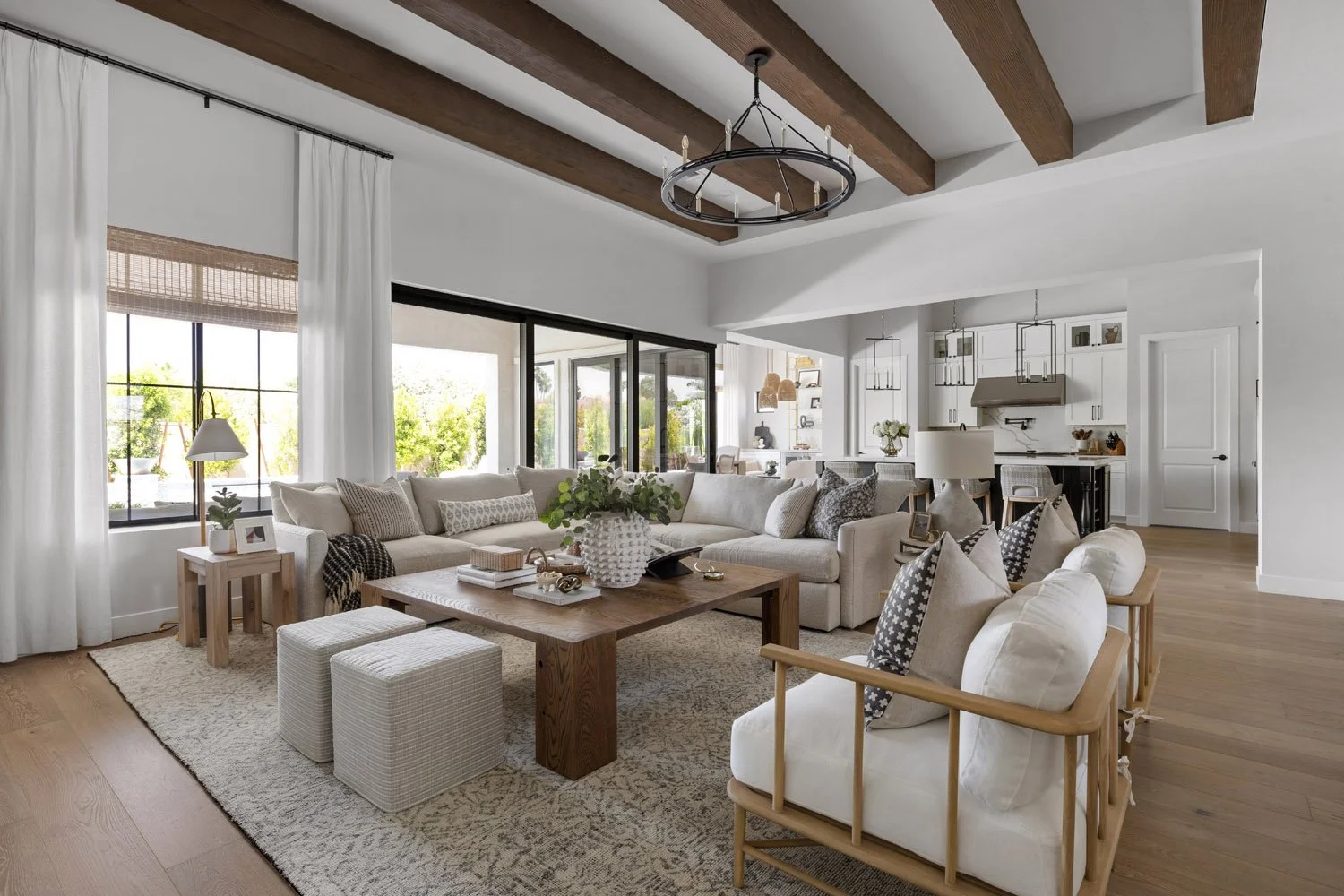 Open plan living room with large neutral sectional and ring chandelierd