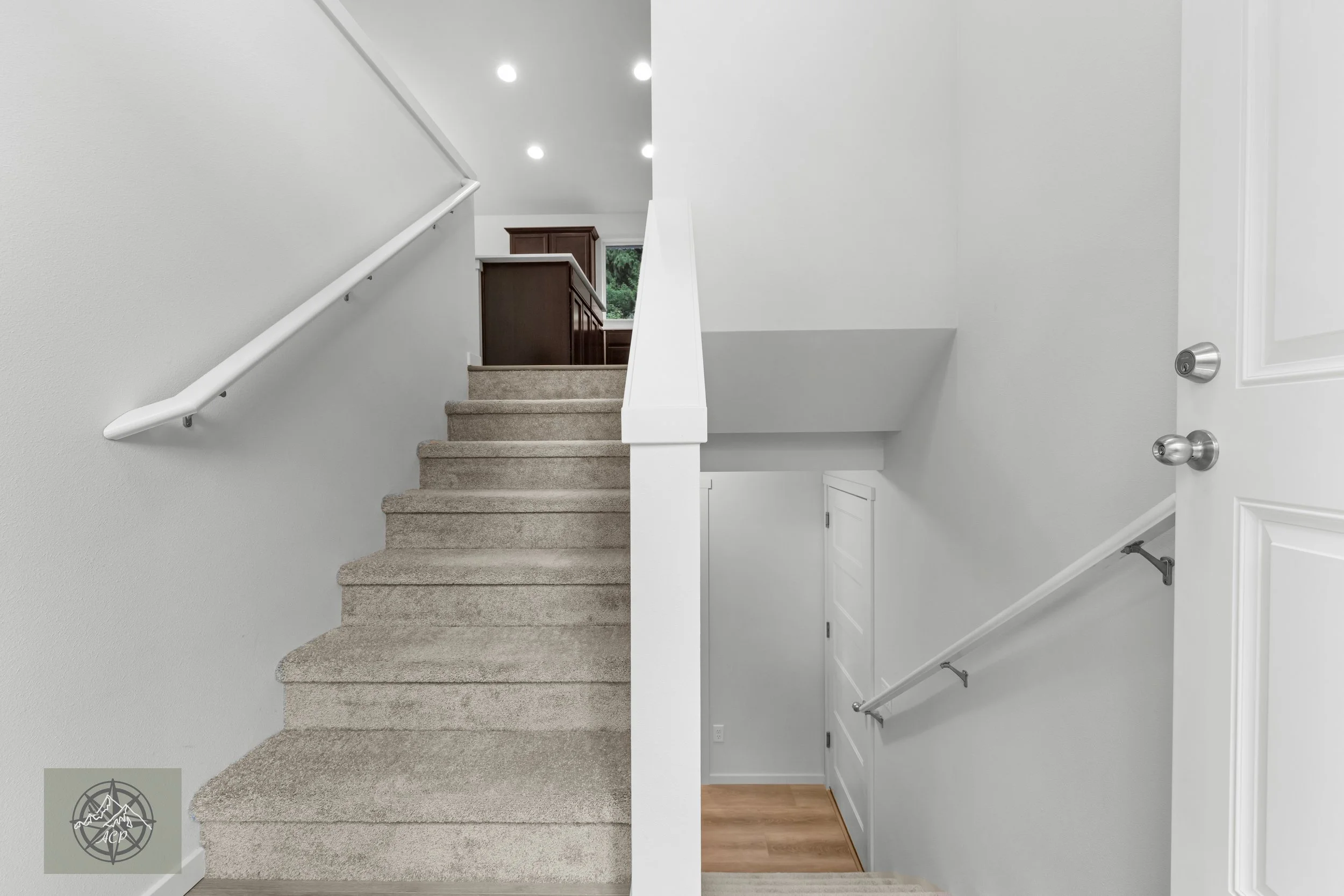 Comparison of two staircases in a house, with the left side showing carpeted stairs and the right side showing a wooden staircase with a white wall and a door at the bottom.