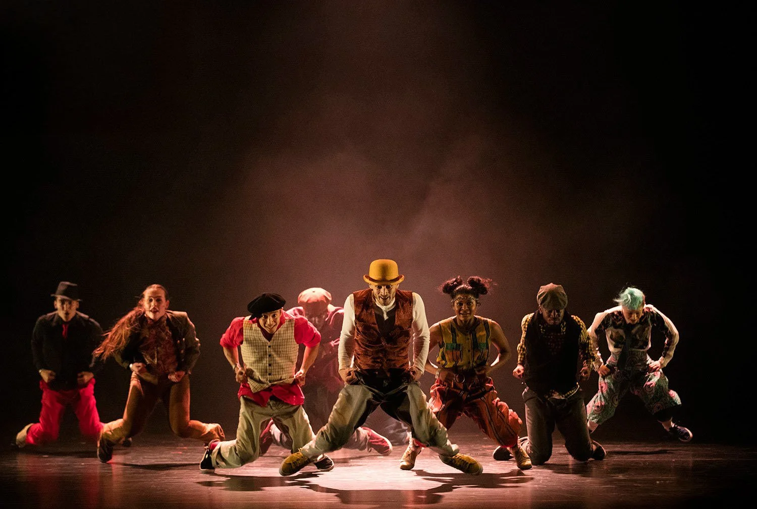 colourful-dancers-bending-knees-smiling-stage.jpg