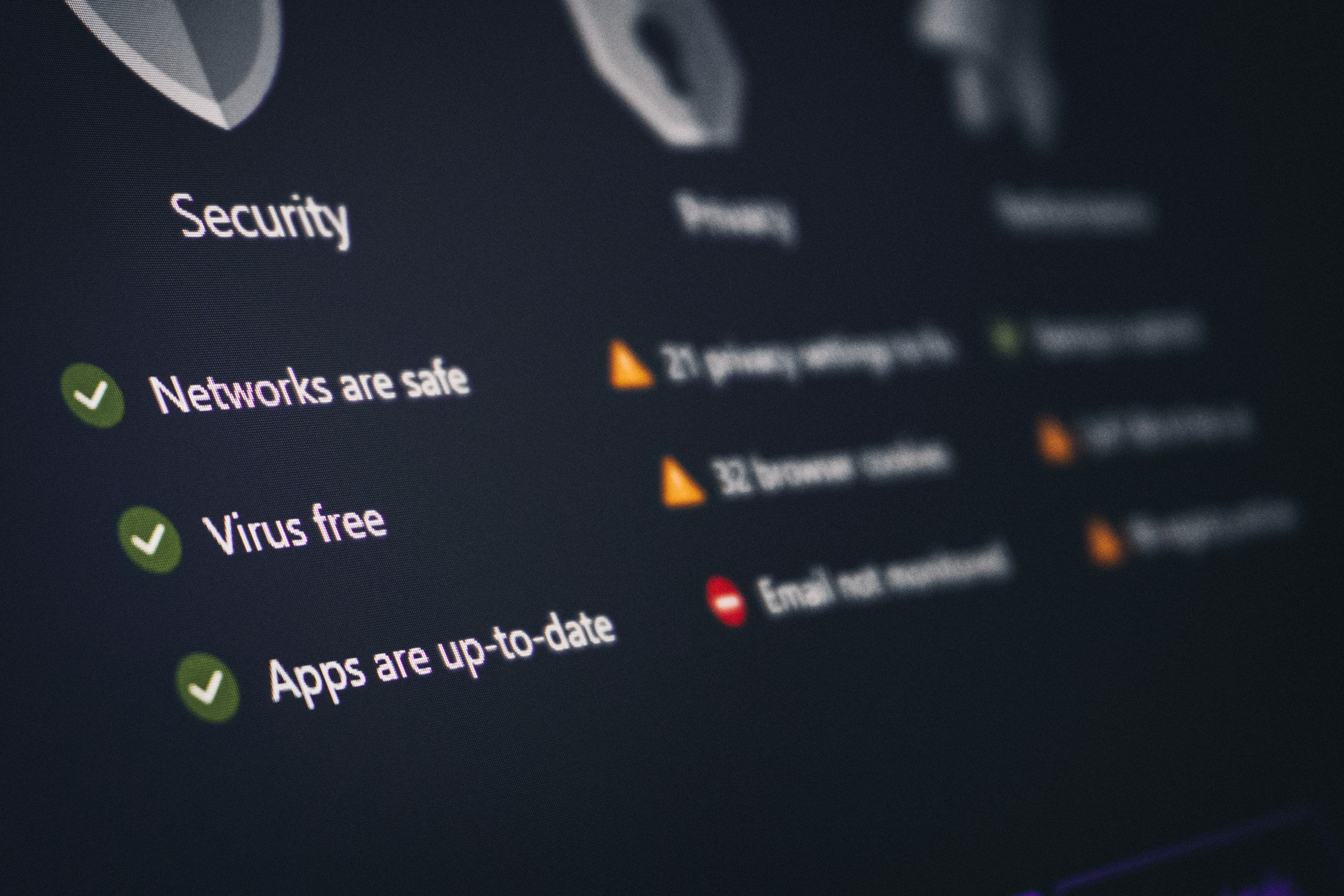 Close-up of a computer screen showing a list of system security status messages, including "Networks are safe" with a green check mark and other status indicators.