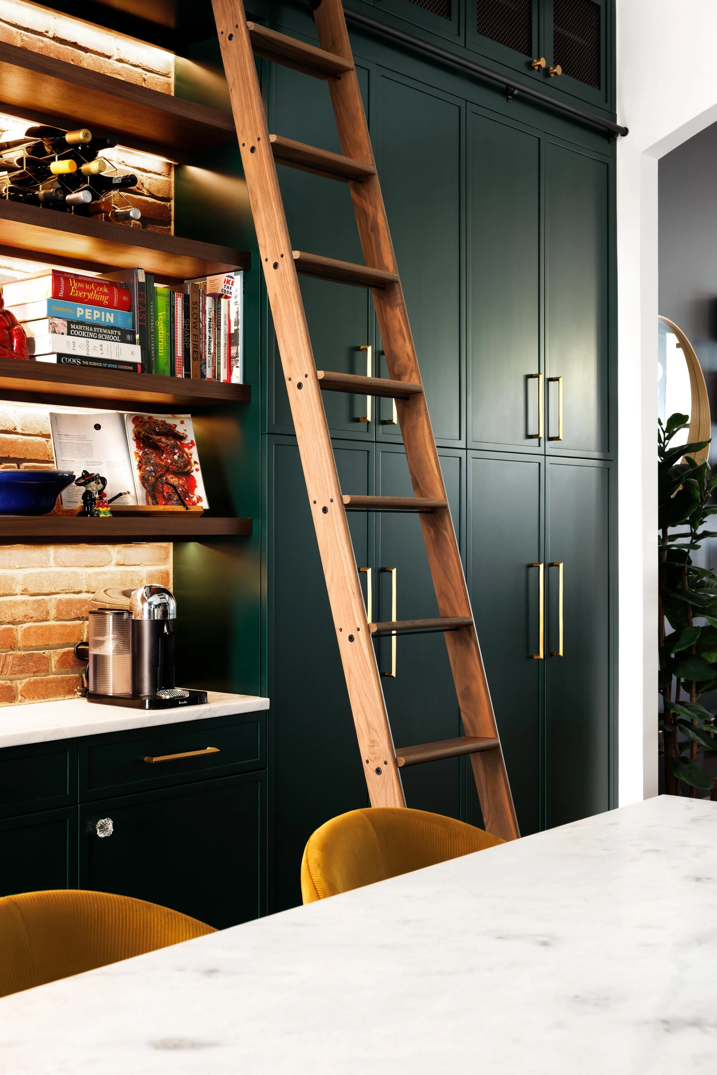 I helped transformed a cramped, walled‑off kitchen and dining room into a unified, social hub complete with an island, breakfast bar, and dry bar. Bold, emerald floor‑to‑ceiling cabinetry—offset by stained walnut floating shelves and exposed brick—ma