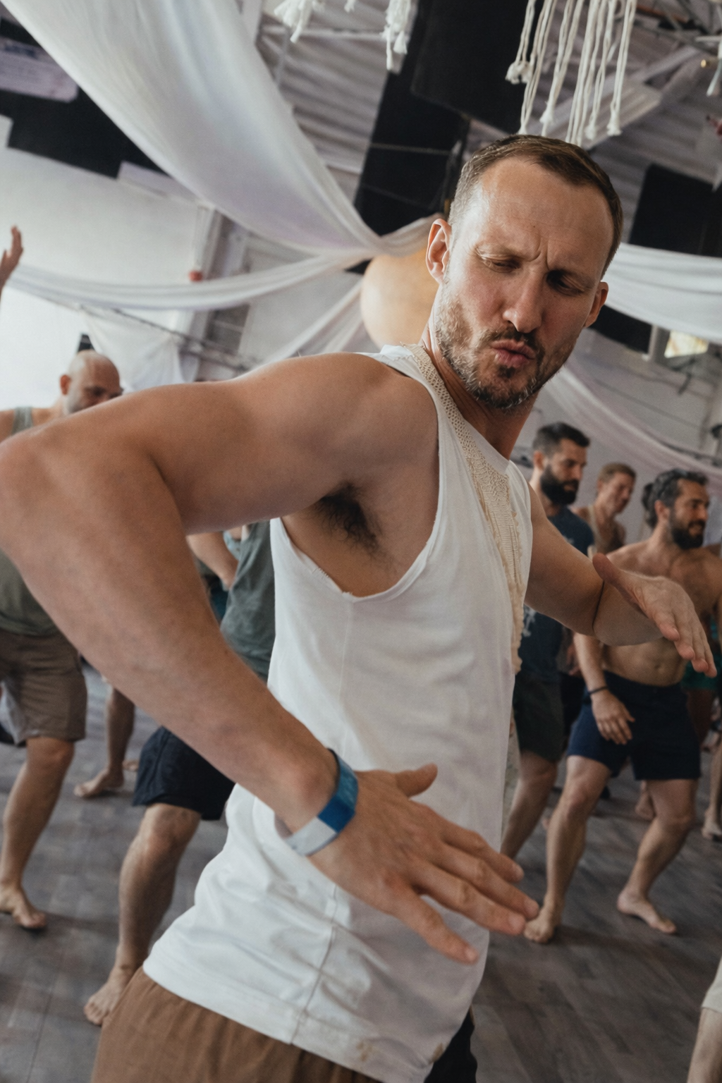 Gay man at ecstatic dance in London dancing freely with eyes closed during an ecstatic dance session, representing uninhibited movement