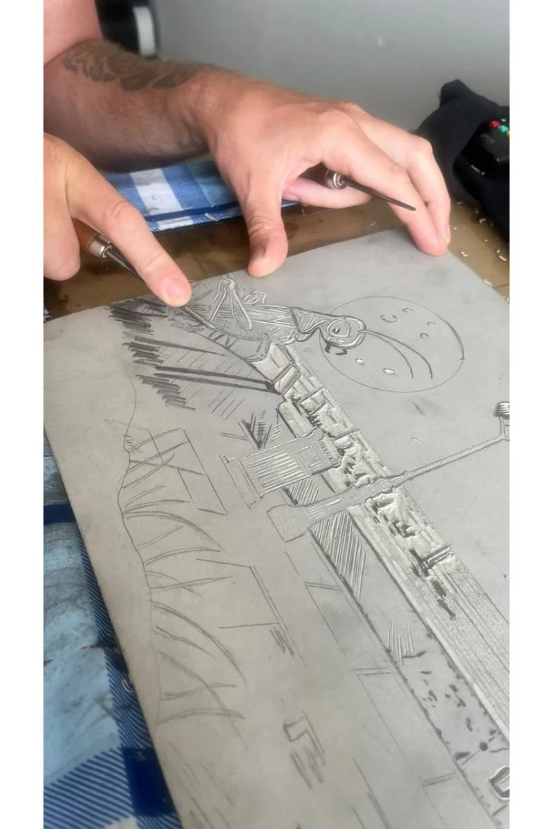 The artist Mark James Murphy carves the linocut