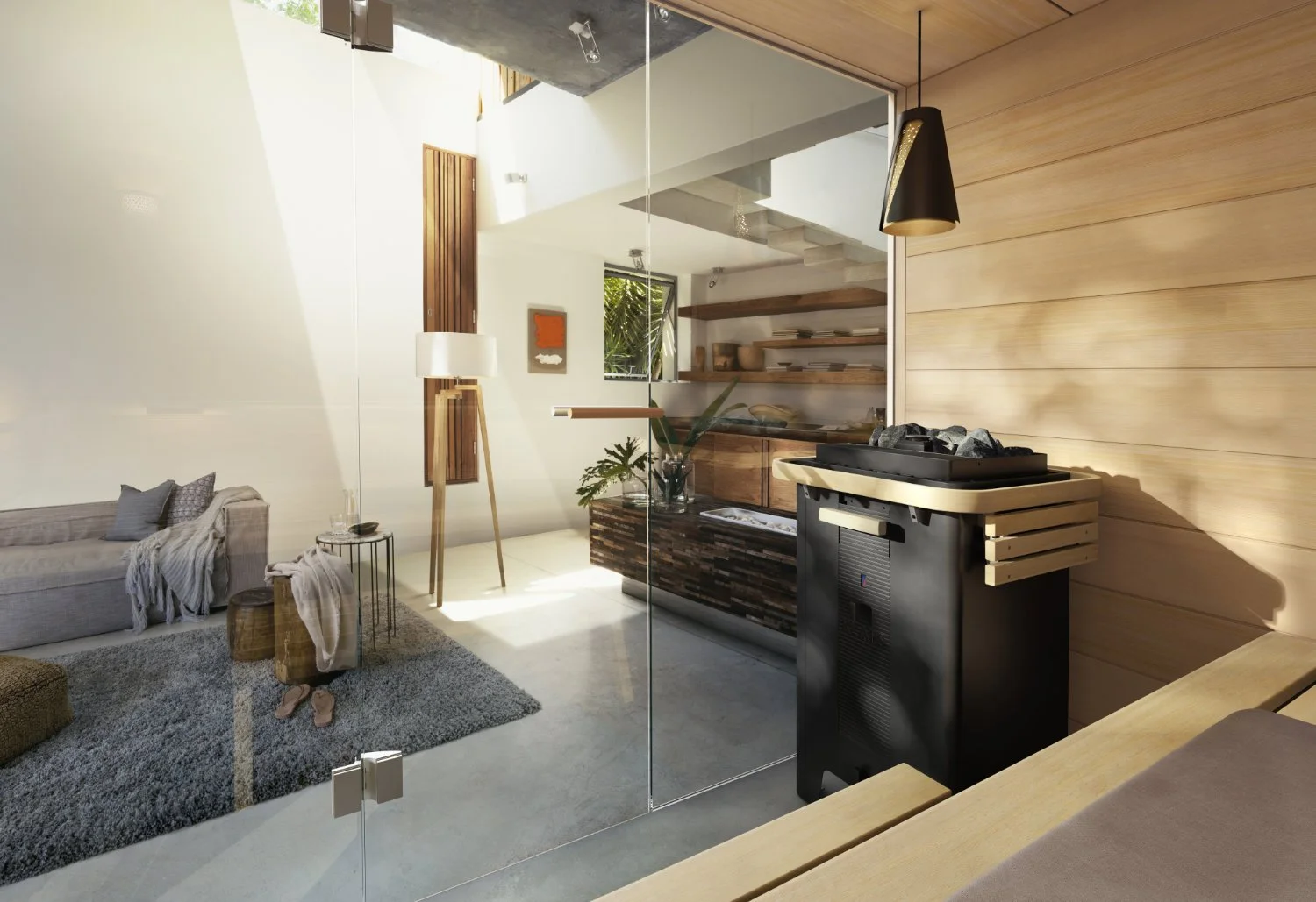 Der Übergang von der gläsernen Saunafront zum offenen Wohnbereich zeigt den schwarzen Saunaofen als funktionales Element im Industrial Design, das sich harmonisch in das moderne Architekturkonzept mit Sichtbeton integriert.