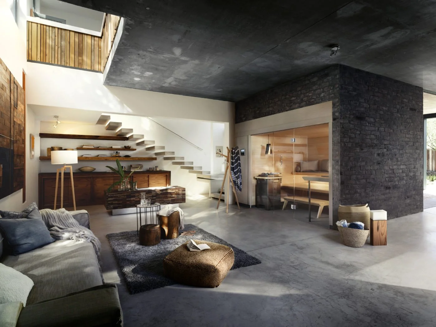 Diese Rauminszenierung verbindet eine minimalistische Sauna im Industrial Design mit einem loftartigen Wohnraum, wobei die Glasfront und die dunkle Ziegelwand eine nahtlose ästhetische Verbindung zwischen Wellness und Wohnen schaffen.