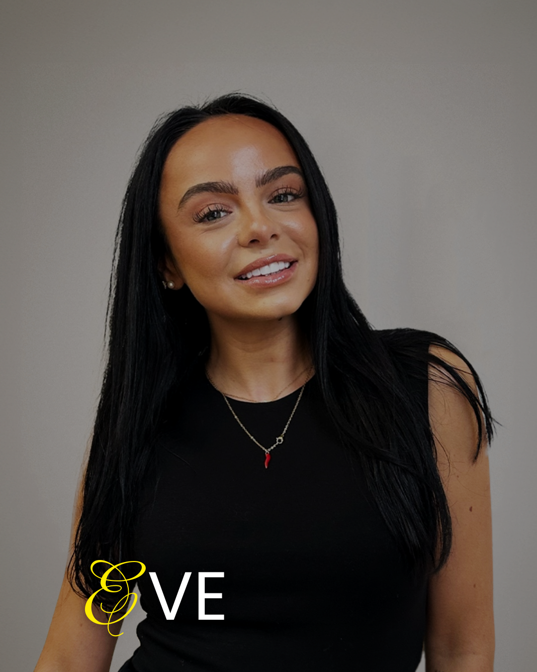 A young woman with long black hair, wearing a black sleeveless top, smiling, with a gray background and the word 'LOVE' partially visible in the bottom left corner.