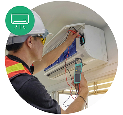Technician working on an air conditioning unit with testing equipment
