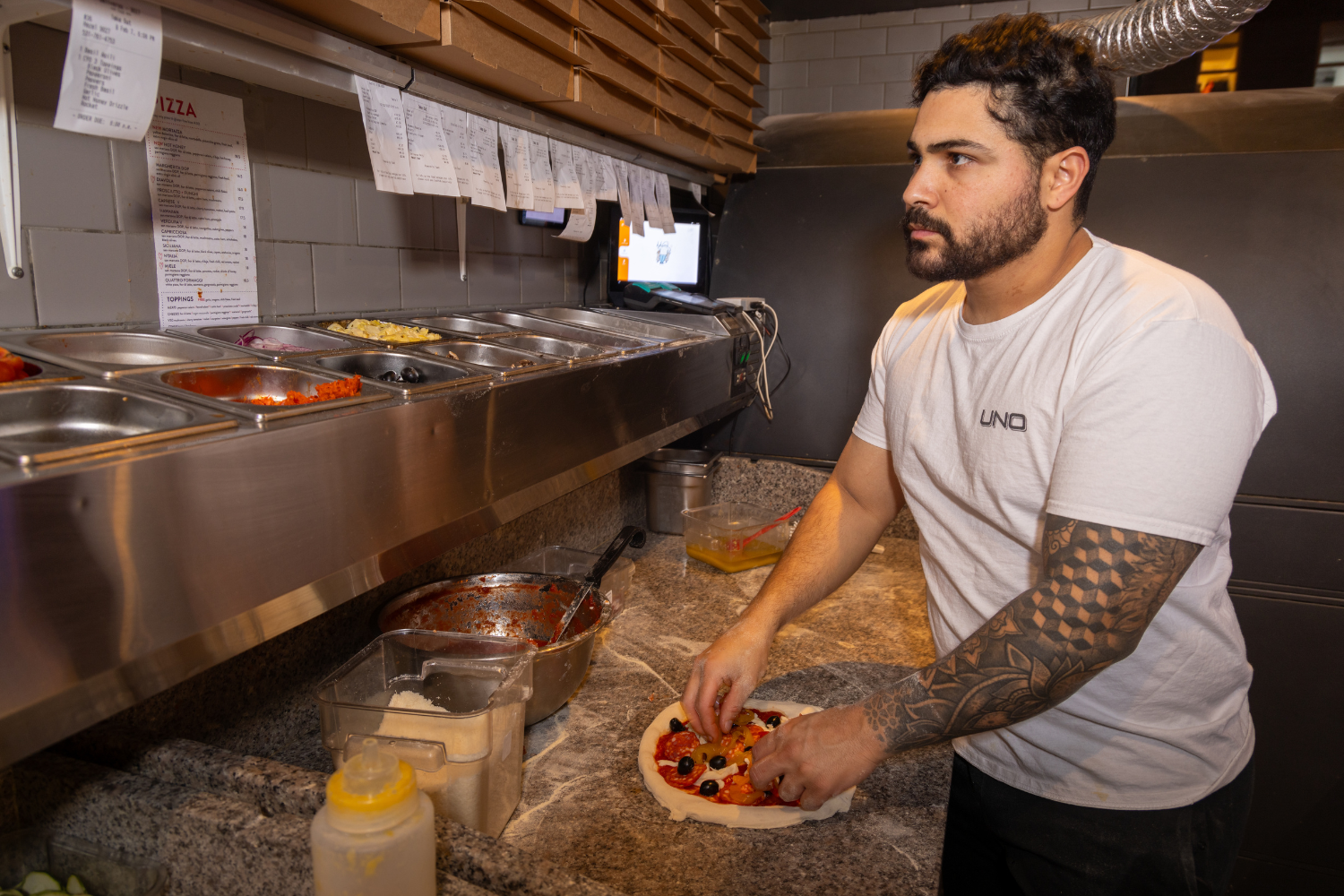 Man looking at tickets orders in the kitchen.png