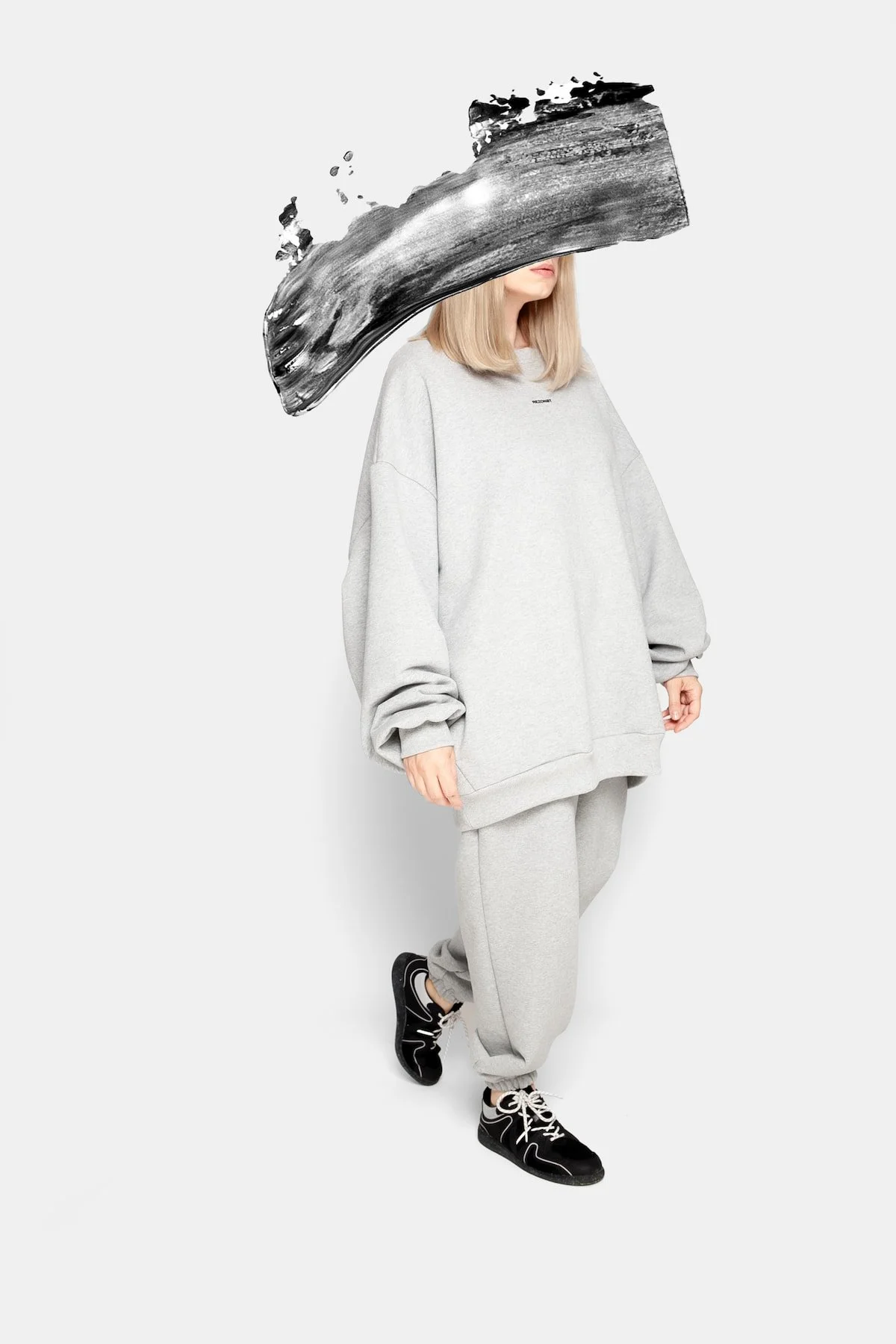 Movement shot of model in REZON8T ESSENCE premium oversized sweatshirt and sweatpants, grey 100% cotton French terry set — modern Danish streetwear made in Europe.