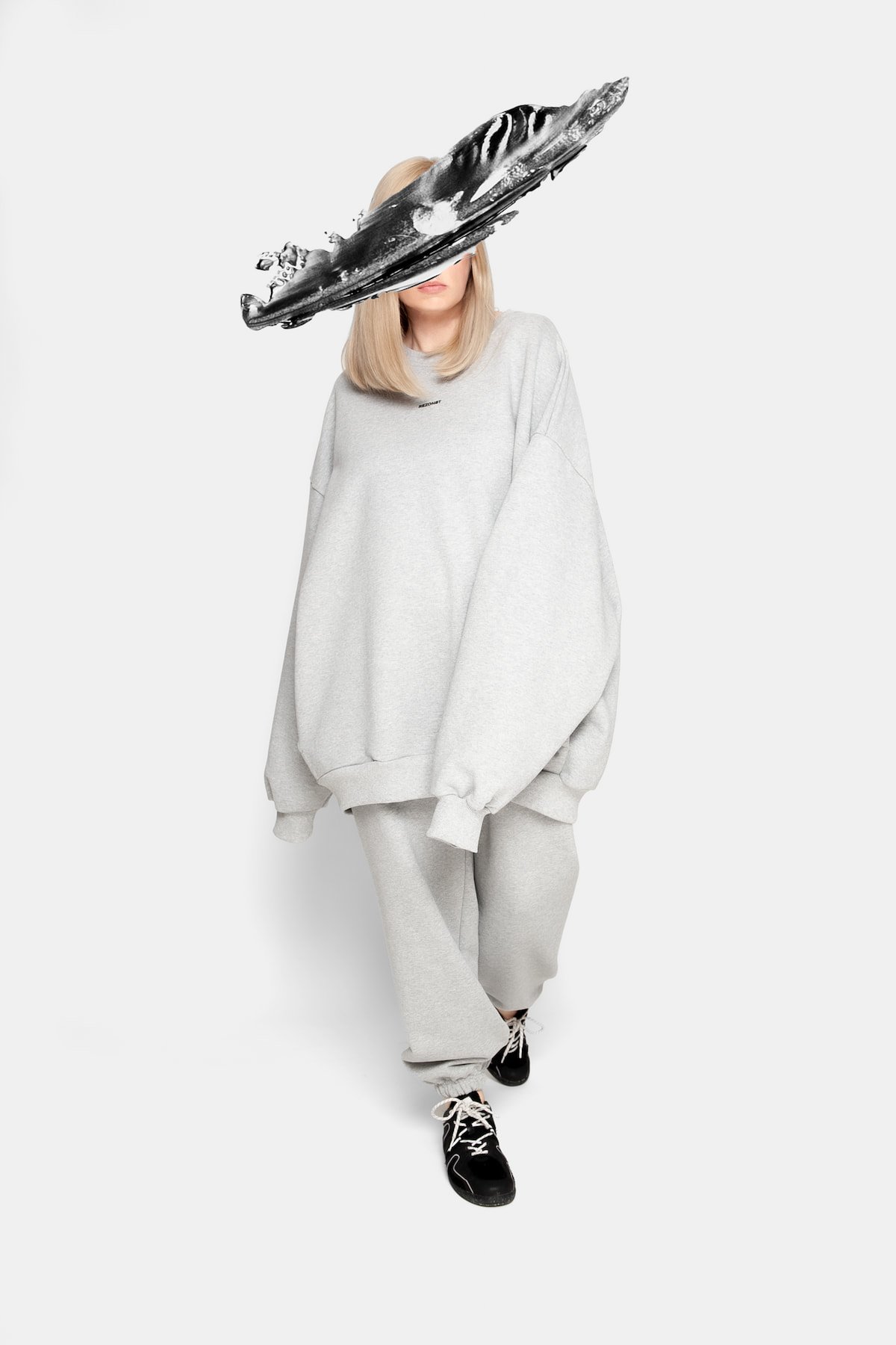 Movement shot of model in REZON8T ESSENCE premium oversized sweatshirt and sweatpants, grey 100% cotton French terry set — modern Danish streetwear made in Europe.