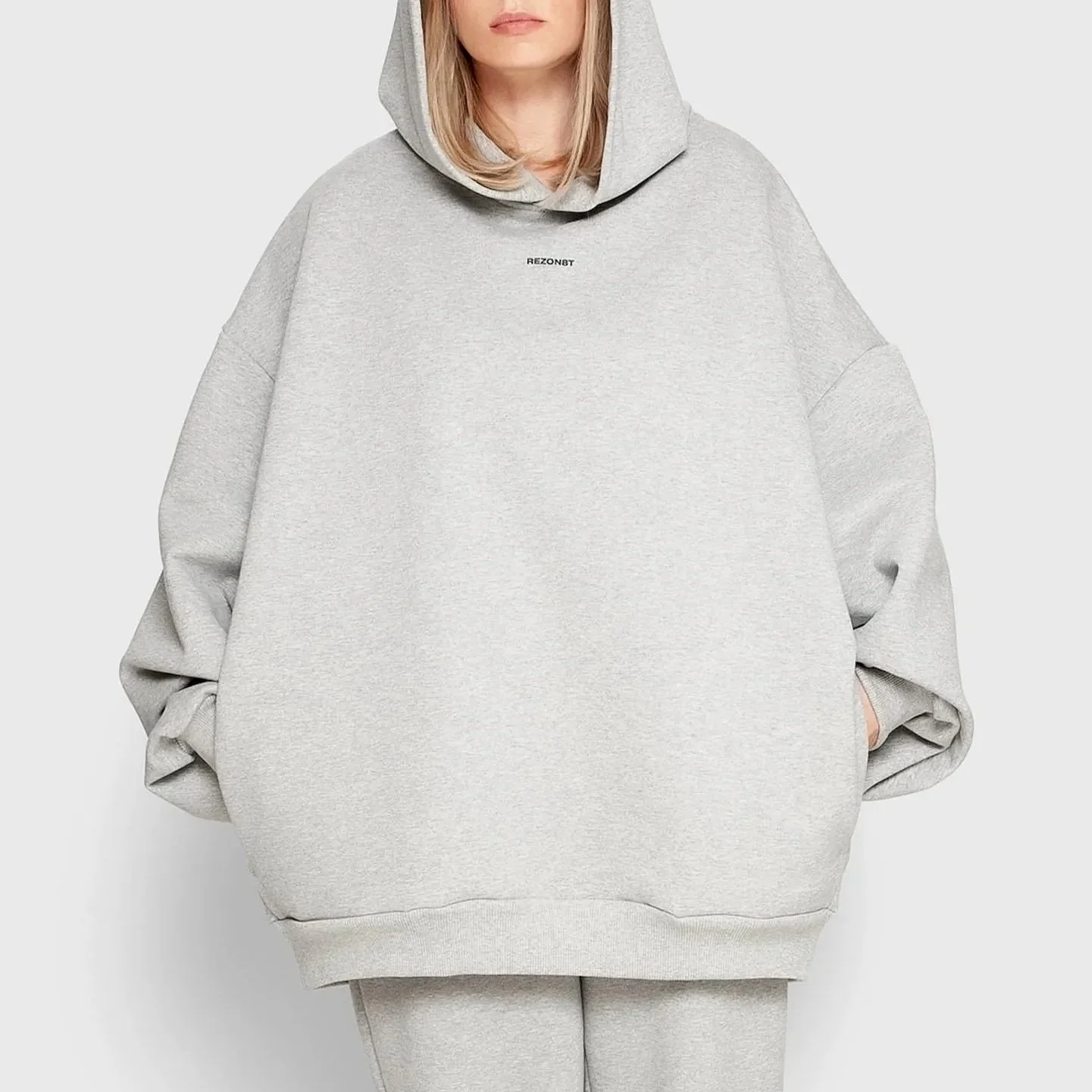 Model wearing REZON8T ESSENCE Collection oversized hoodie in grey — premium 100% French terry cotton, designed in Denmark and crafted in Europe. Limited-edition minimalist streetwear.