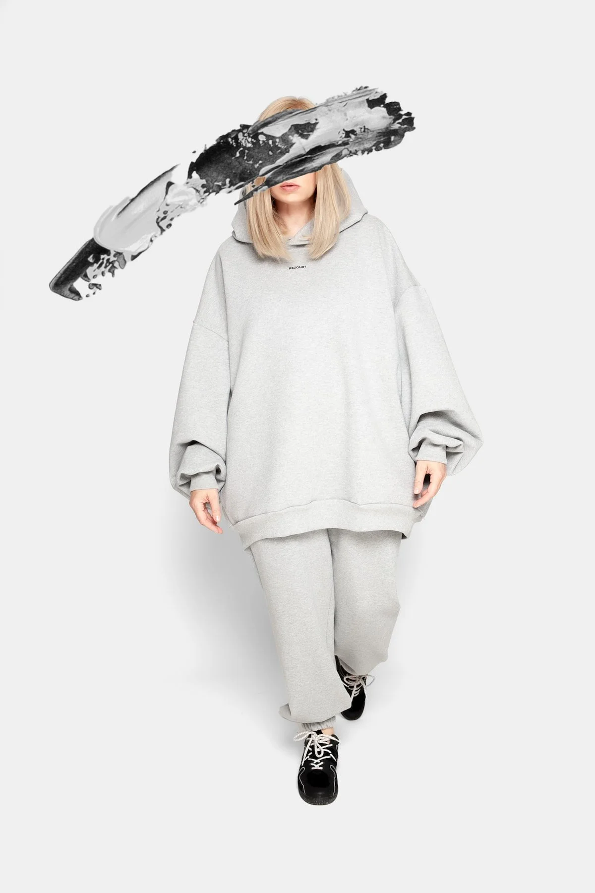 Side view of REZON8T ESSENCE grey oversized hoodie and sweatpants set, showcasing relaxed silhouette and luxury European craftsmanship in soft French terry cotton.