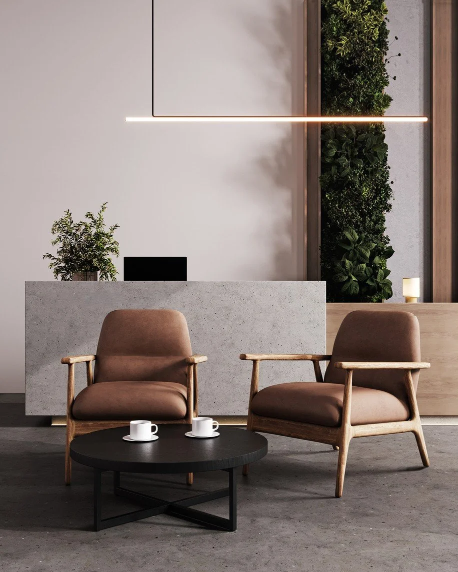 Un salon moderne avec deux fauteuils en bois et en tissu beige, une table basse noire avec deux tasses, un comptoir en béton avec une plante et un ordinateur portable, ainsi qu'un mur avec une décoration végétale et un éclairage suspendu