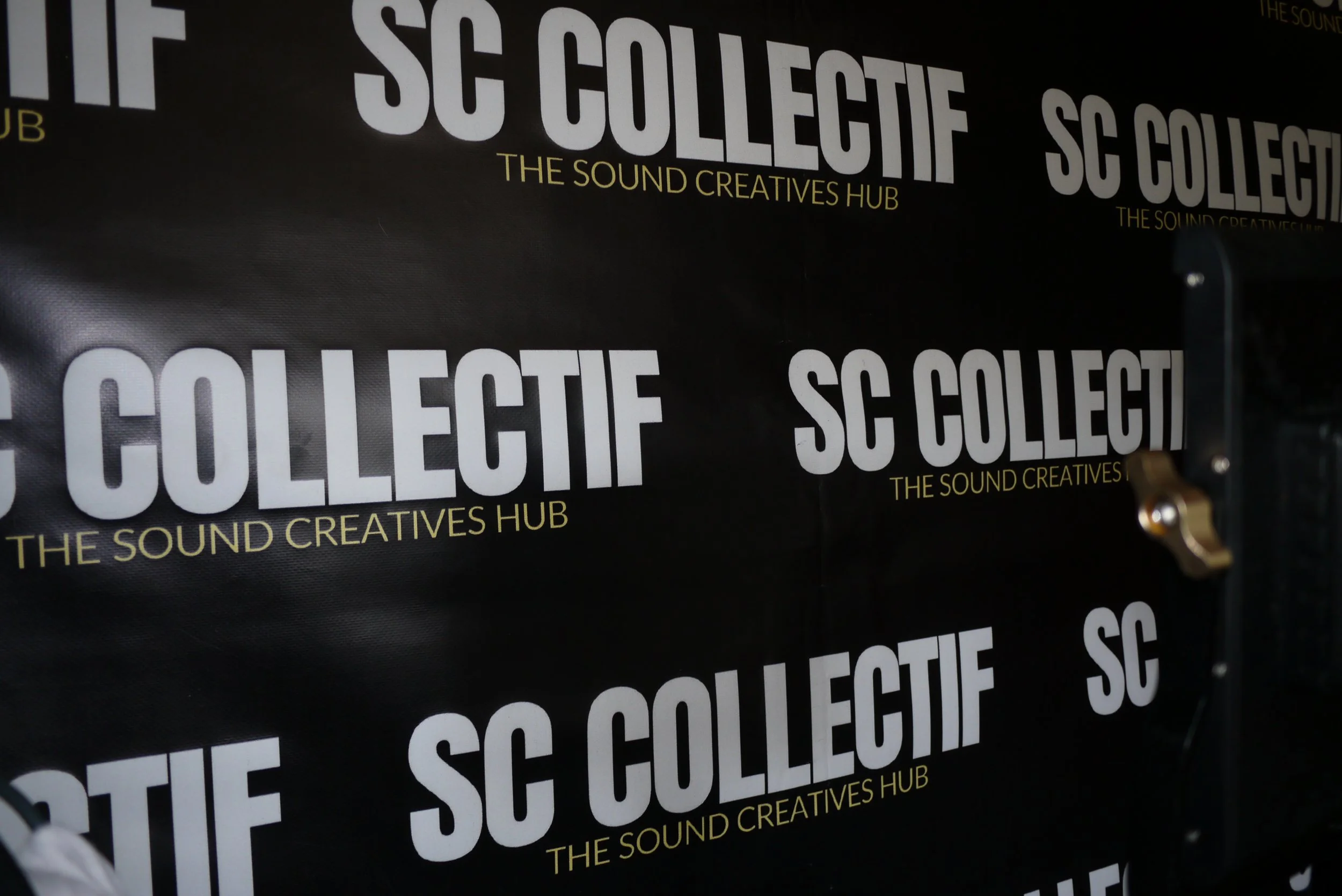 Black banner with high contrast white and yellow text reading 'SC COLLECTIF' and 'THE SOUND CREATIVES HUB' repeated multiple times.
