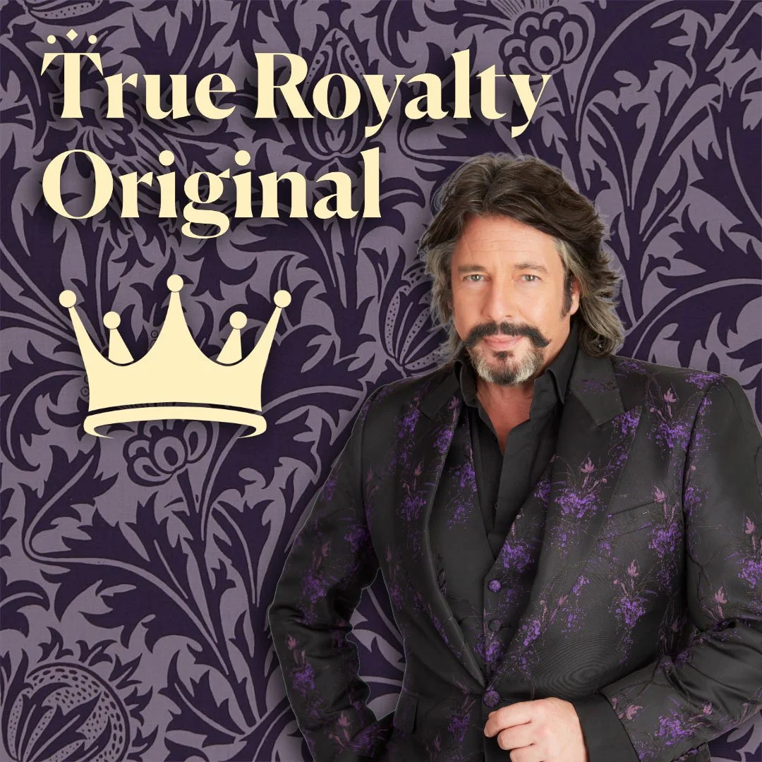 A man with wavy brown hair and a beard wearing a black suit with purple floral patterns, standing against a purple background with a floral design. There is a cream-colored crown graphic and the text 'True Royalty Original' in beige.