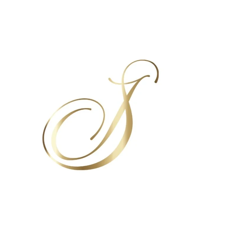 Elegante goldene Schreibschrift eines Buchstabens auf weißem Hintergrund.