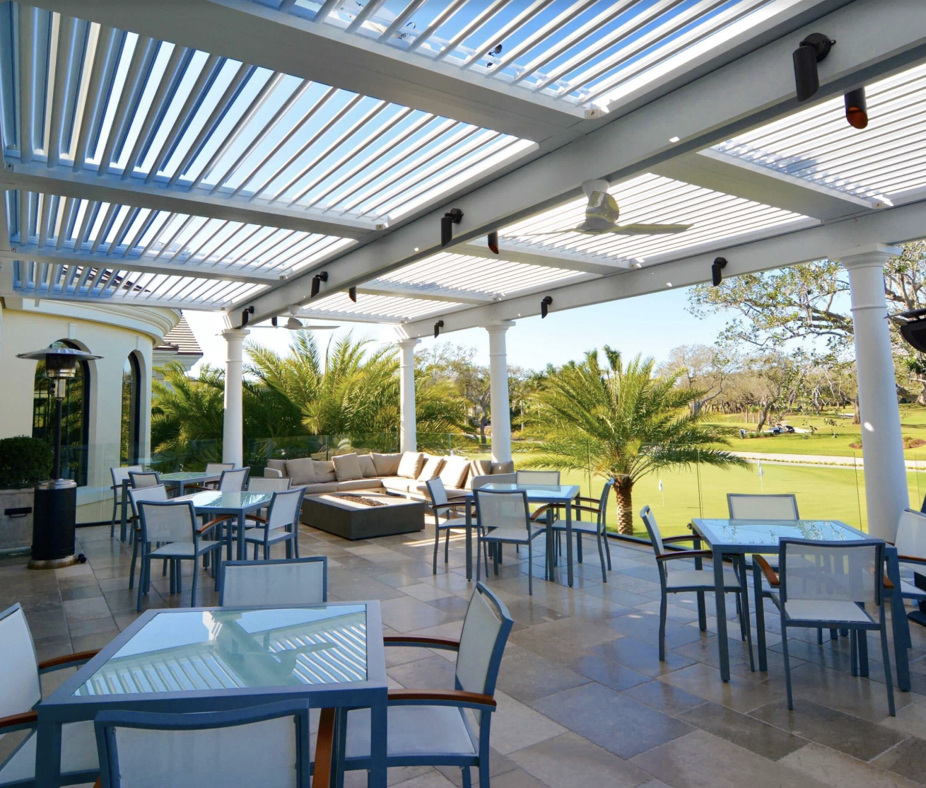 Outdoor patio with tables, chairs, and a lounge area under a pergola.