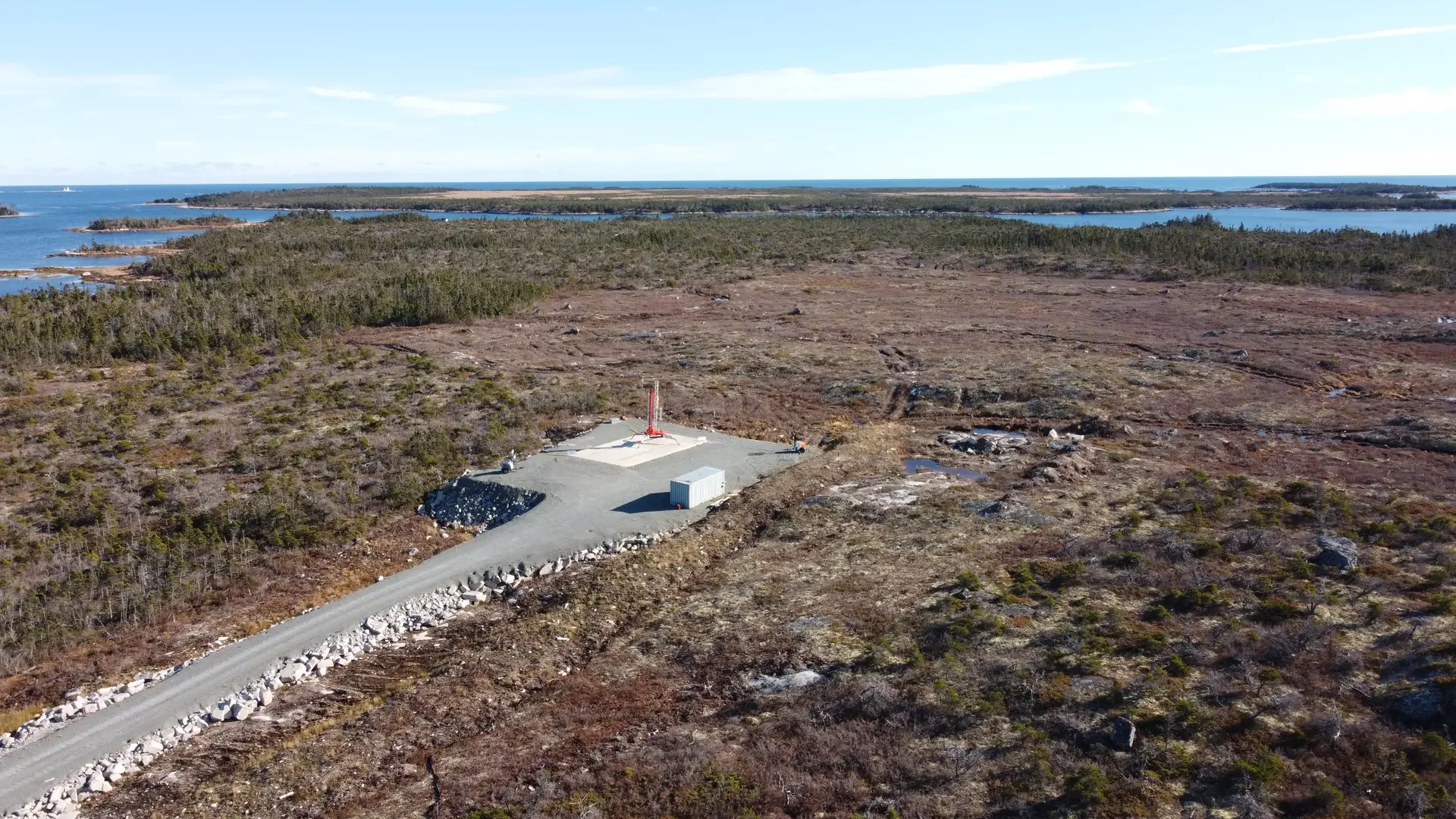 Aerial view of a remote Nova Scotia site supported by Kluskap Security Services, showing the access road, coastal terrain and work area.