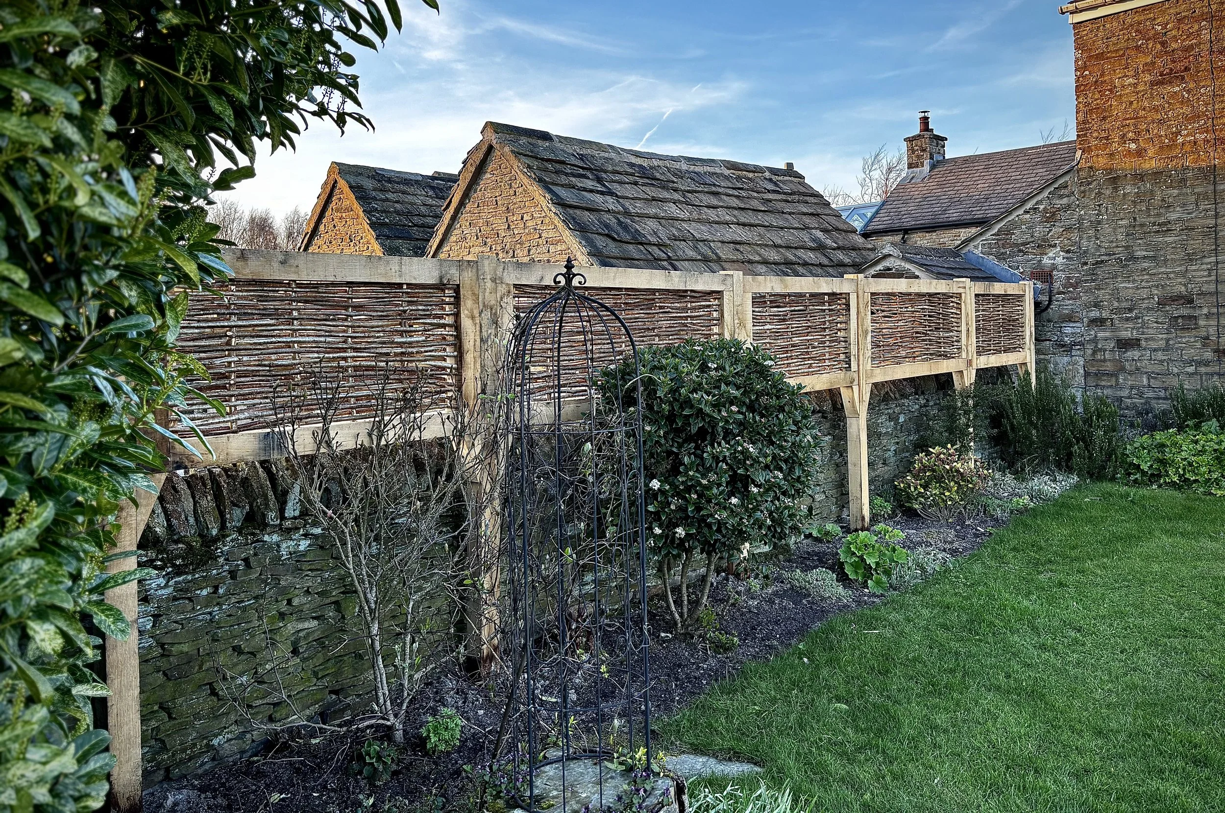 Split hazel infill surrounded by oak to increase the privacy in this garden