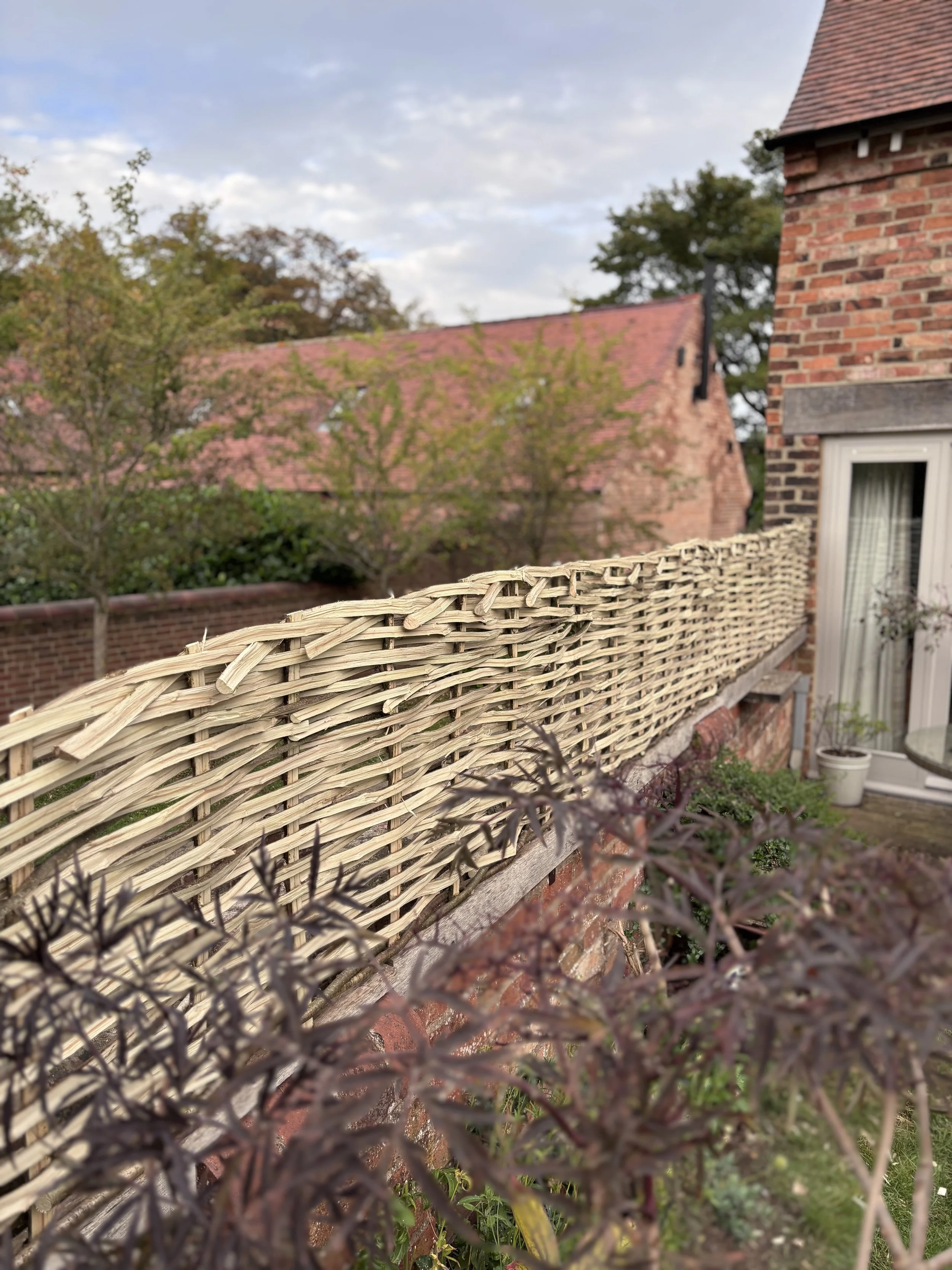 A Hazel hurdle woven in situ on an Oak timber to offer a little more privacy.