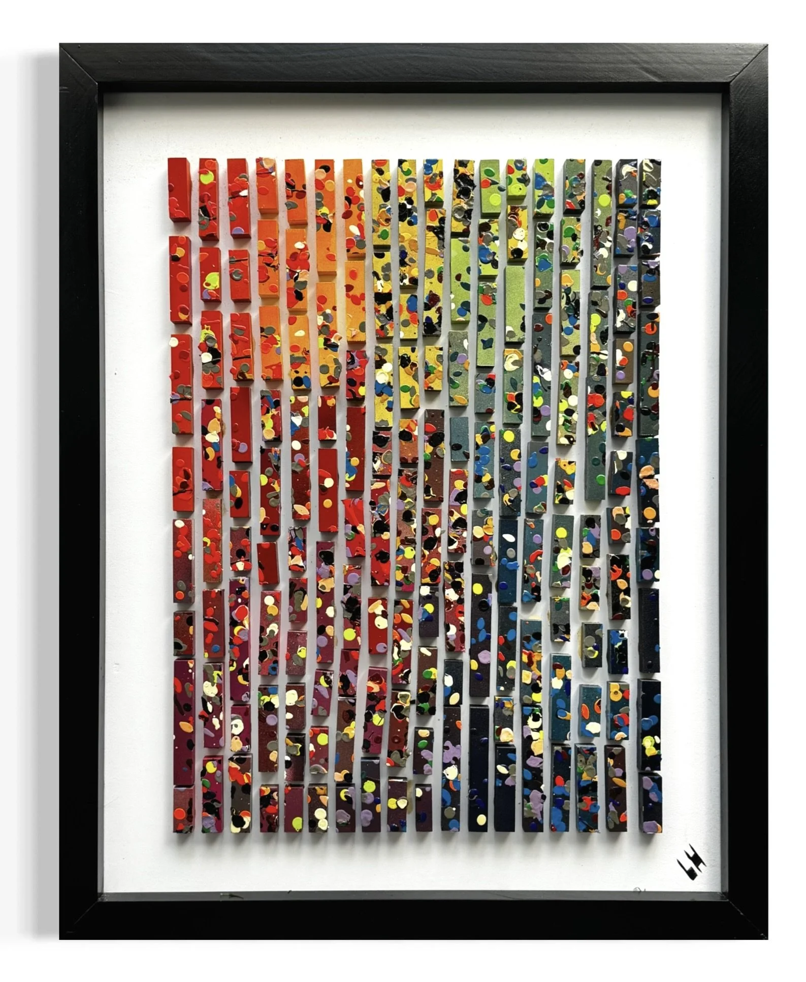 Colorful abstract artwork made of small, rectangular, pixel-like pieces arranged in vertical columns within a black frame.